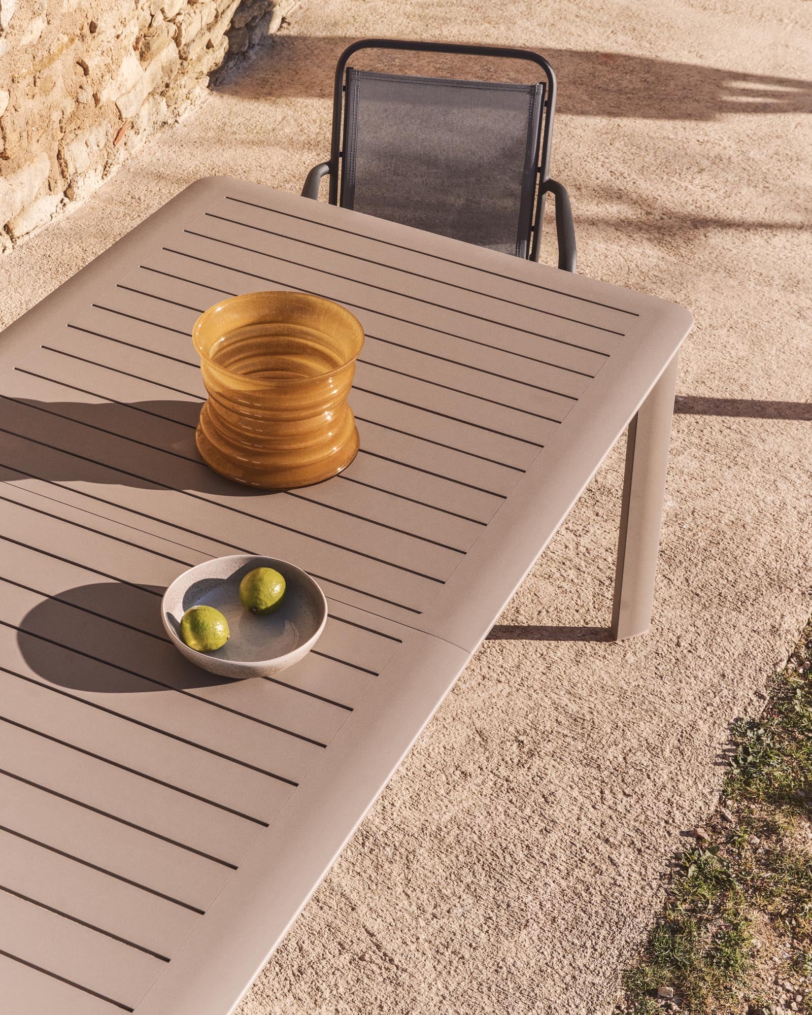 Eleganter stapelbarer Gartenstuhl Luri aus robustem Aluminium in Graphit, mit komfortablen Armlehnen und atmungsaktivem Texteline in Grau.