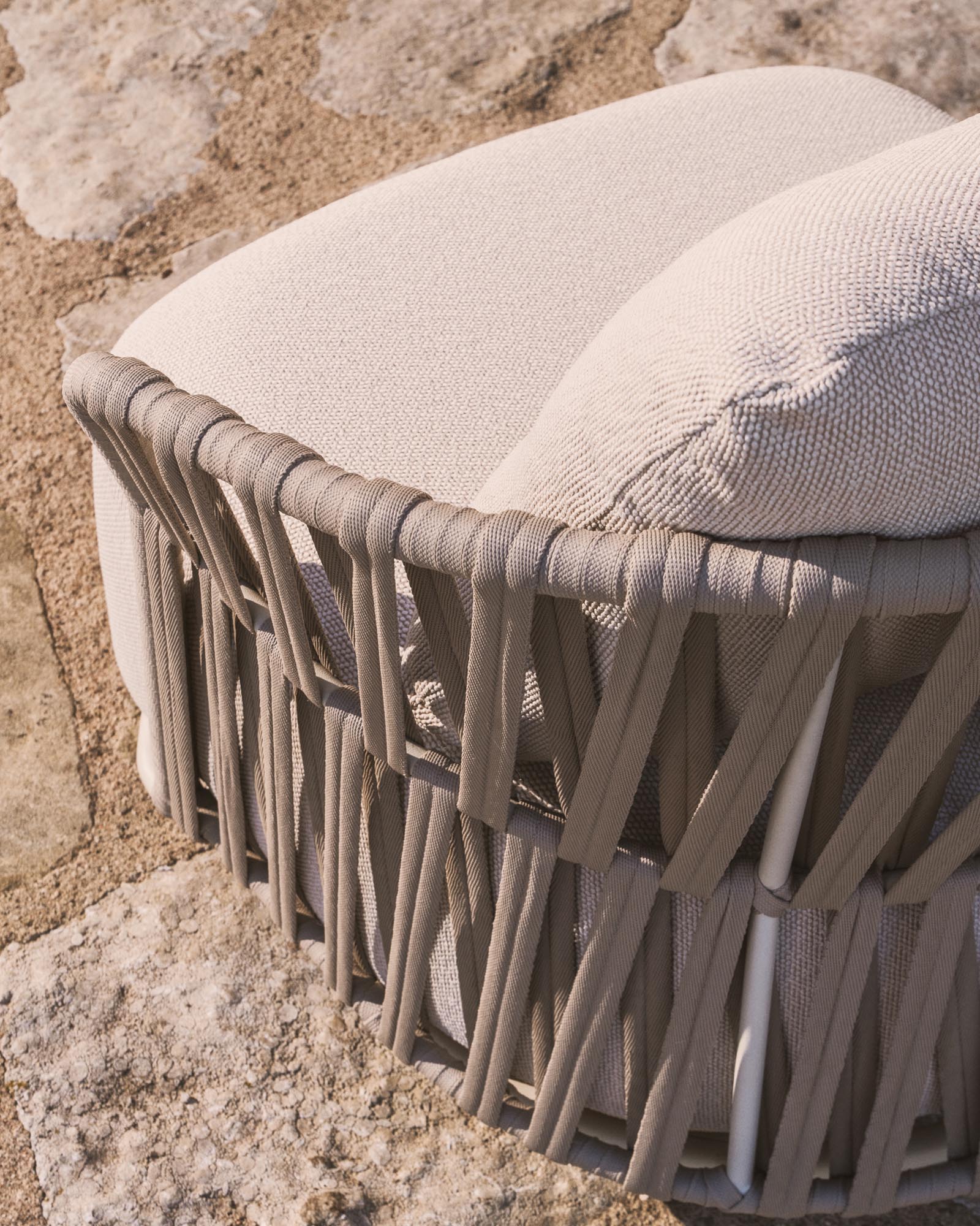 Elegantes Lounge Sofa Osani mit geschwungenem Design, gefertigt aus ecrufarbenem Aluminium und taupefarbenem Seil, ideal für stilvolle Außenbereiche.