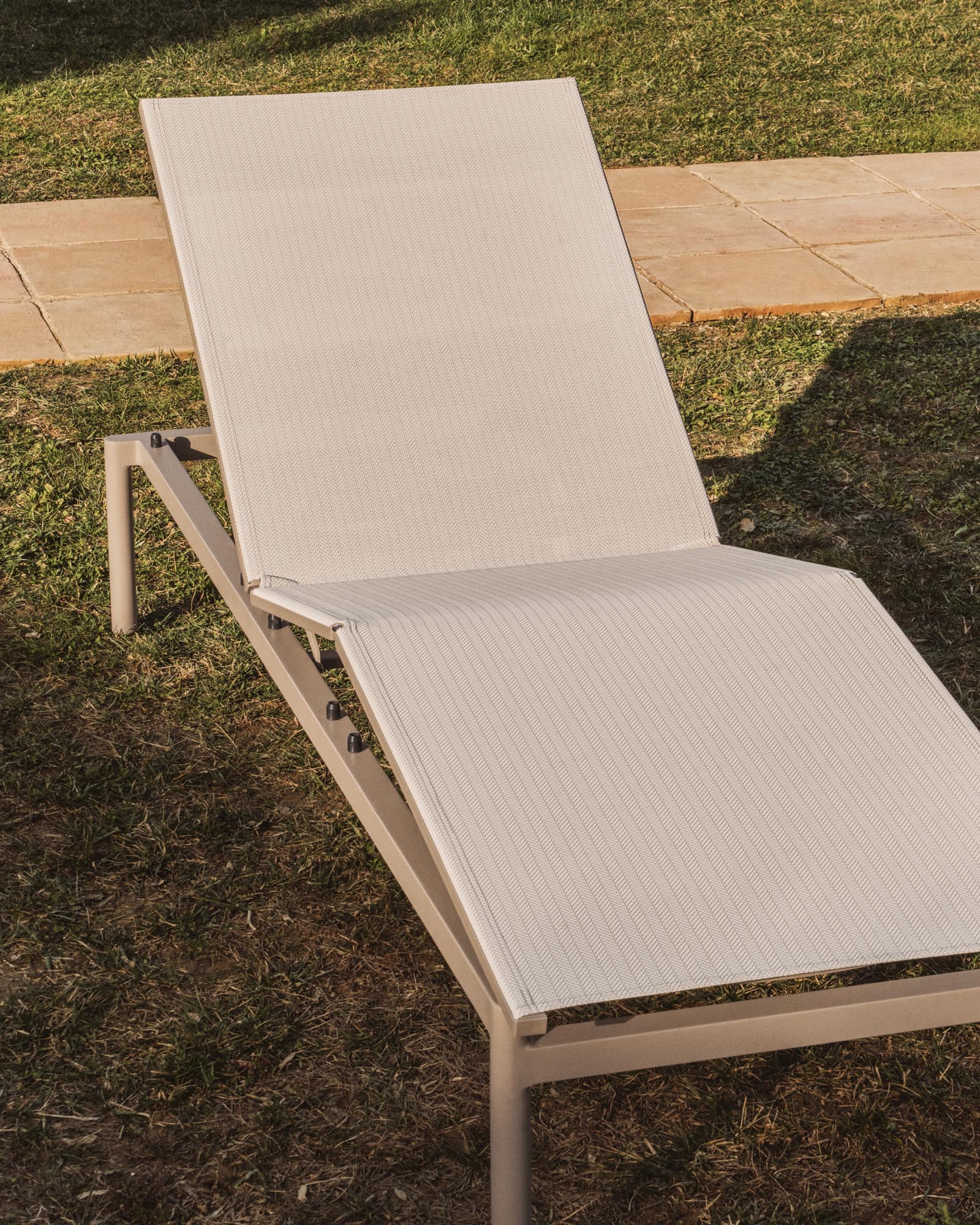 Elegante stapelbare Sonnenliege Lesina in taupe und Ecru, ideal für entspannte Stunden im Freien, präsentiert von Kave Home.