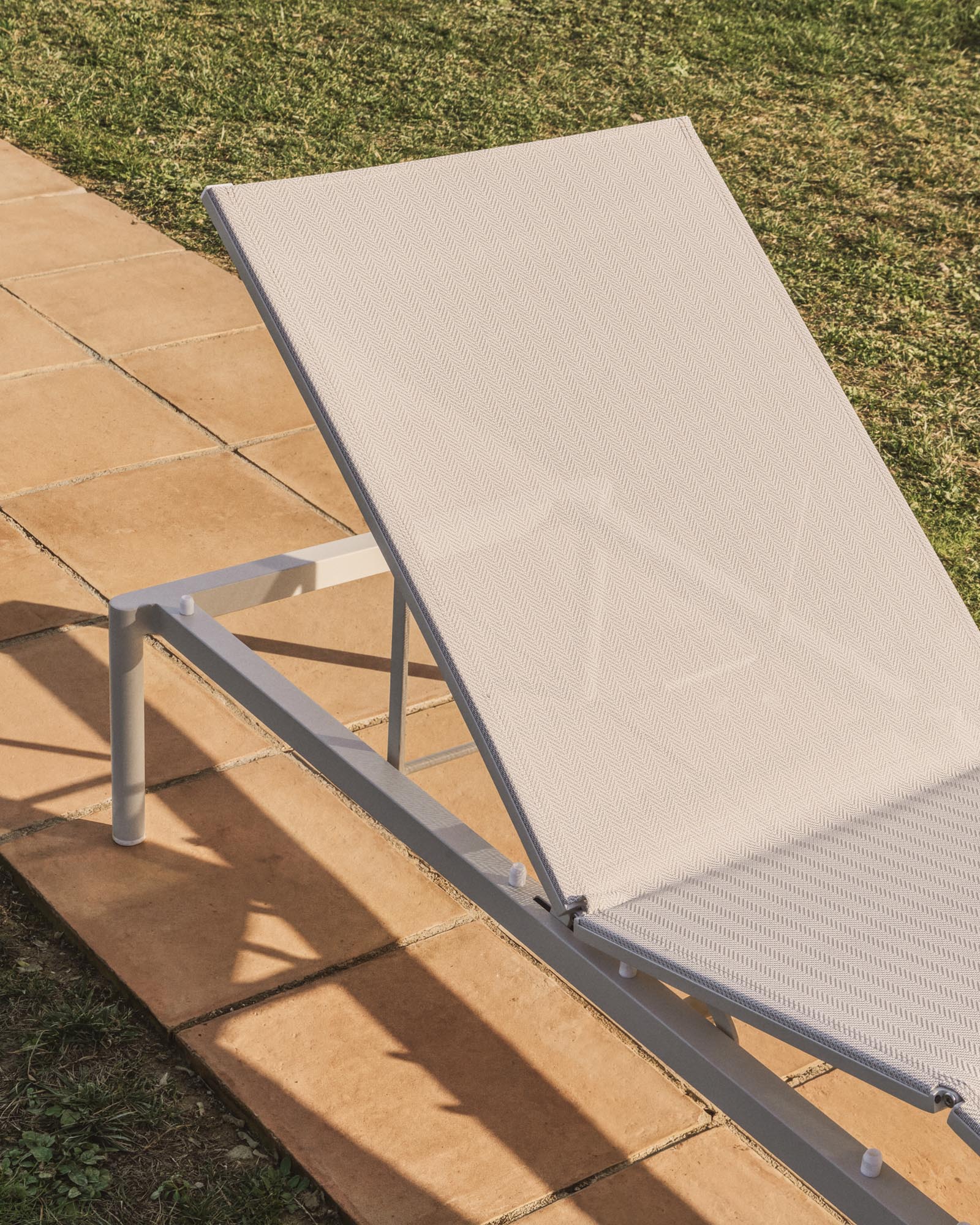 Elegante stapelbare Sonnenliege Lesina aus leichtem Aluminium und stilvollem ecrufarbenem Texteline, ideal für entspannte Stunden im Freien.