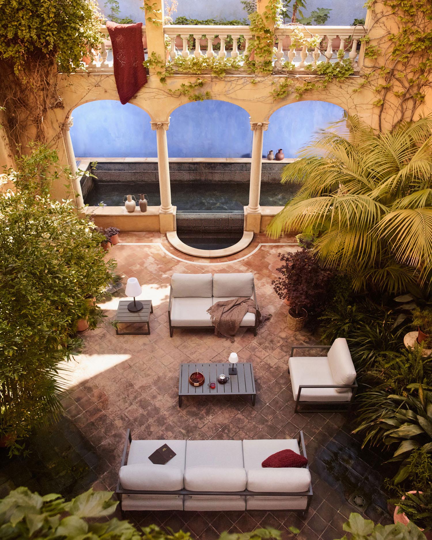 Entdecken Sie den Comova Sessel von Kave Home: stilvoll, wetterfest und perfekt für Ihren Außenbereich mit hellgrauen Polstern und grünem Aluminium.