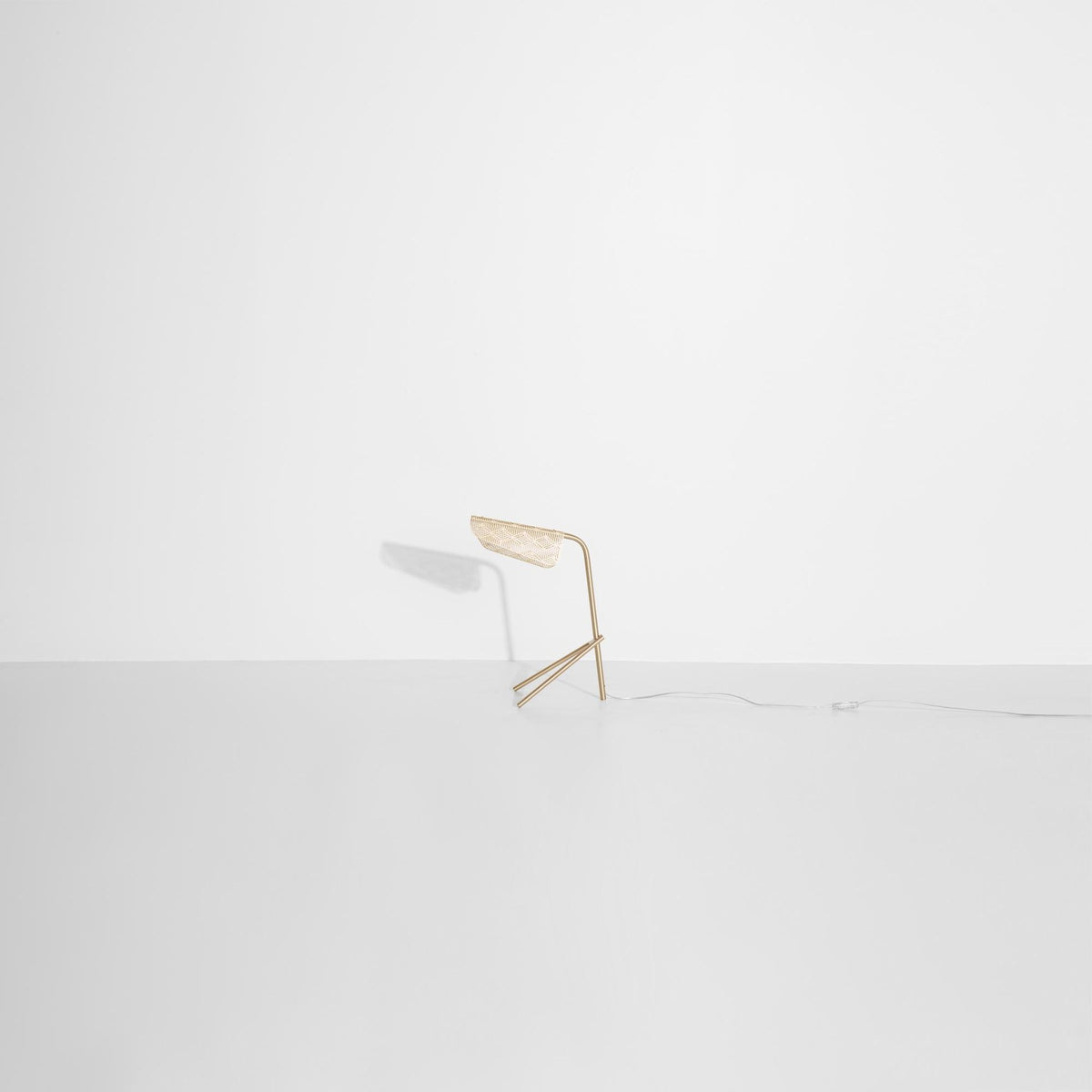Tischlampe Mediterranea aus gebürstetem Messing mit spitzenartiger, durchbrochener Struktur und Kunststoffkabel, freigestellt fotografiert.