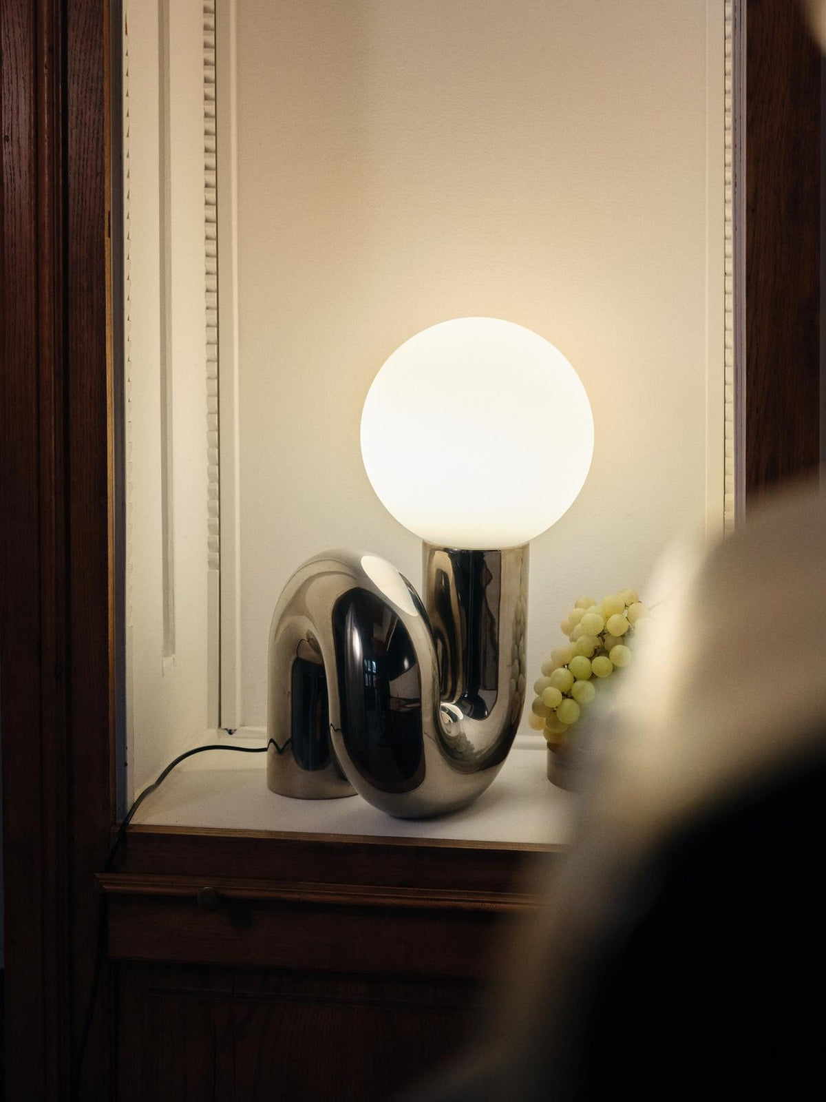 Grosse Tischlampe Neotenic von Petite Friture mit glänzend kirschrot glasiertem Keramiksockel und sandgestrahltem weissem Glasglobus in geschwungener Form.