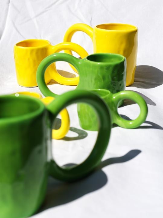 Zwei Espressotassen aus Tonwaren in Pistazie mit glänzender Glasur und donutförmigem Henkel, handwerklicher Look, von Petite Friture