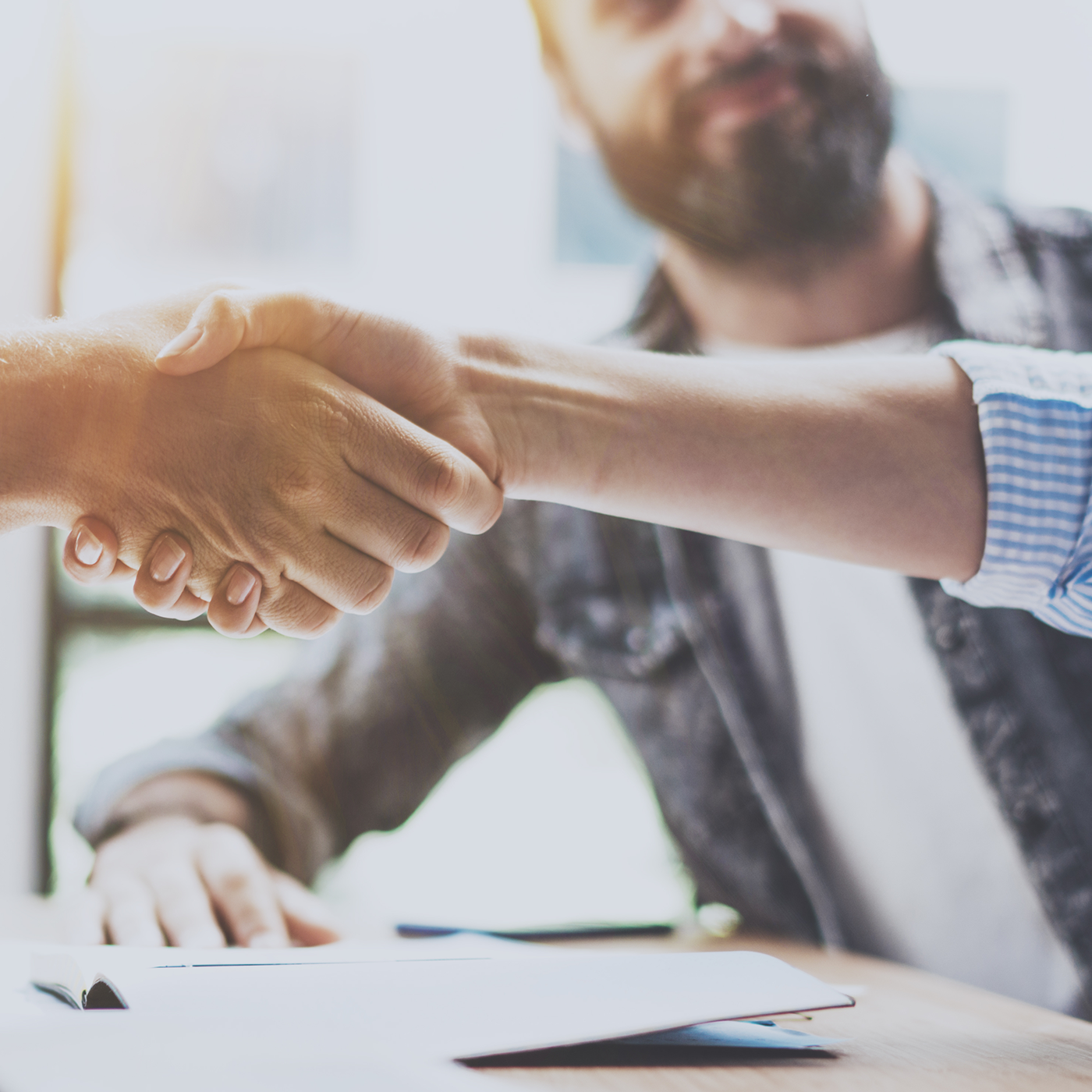 Zwei Personen geben sich die Hand um eine Abmachung zu fixieren