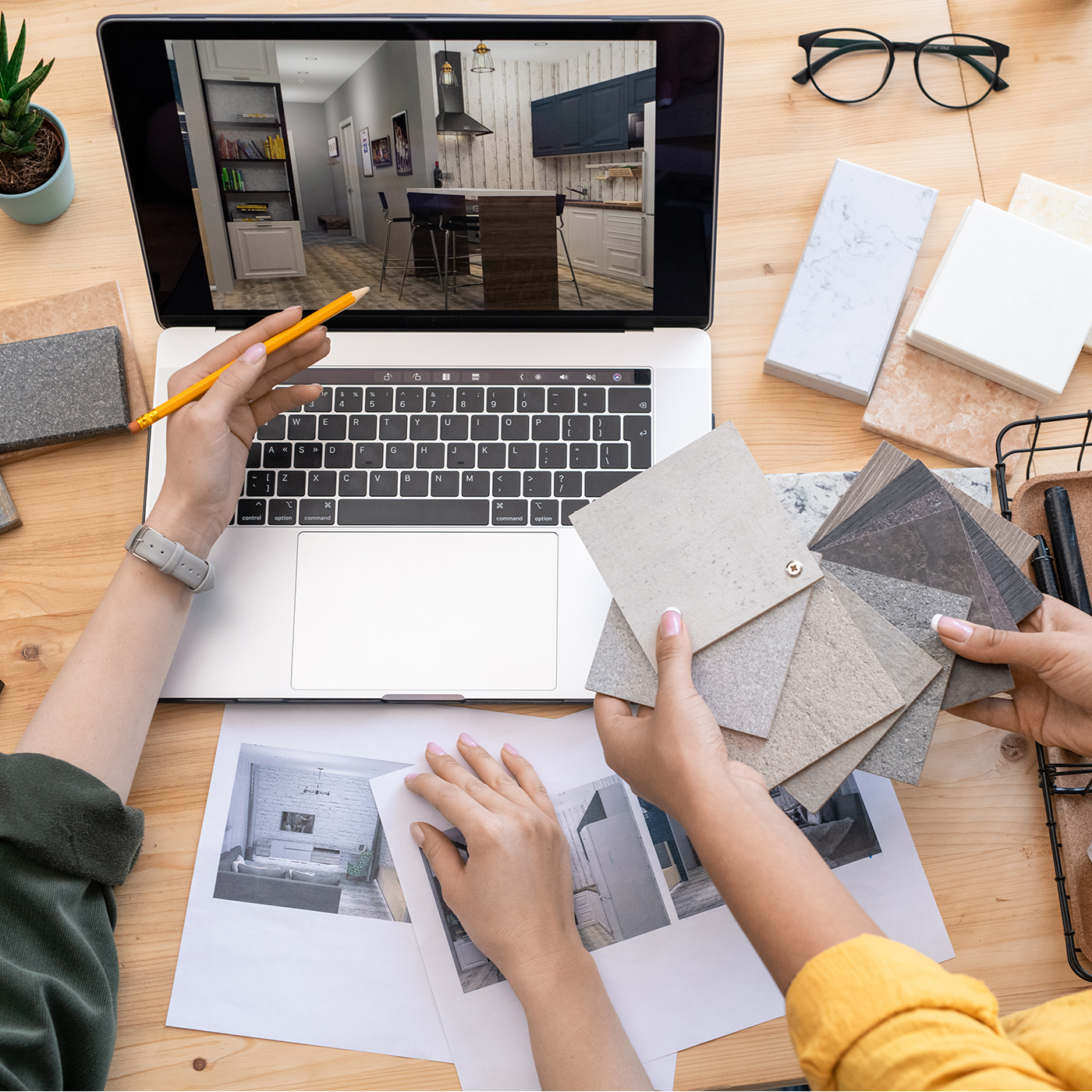 Professionelles Team diskutiert mit physischen Materialien und Laptop einen Einrichtungsvorschlag