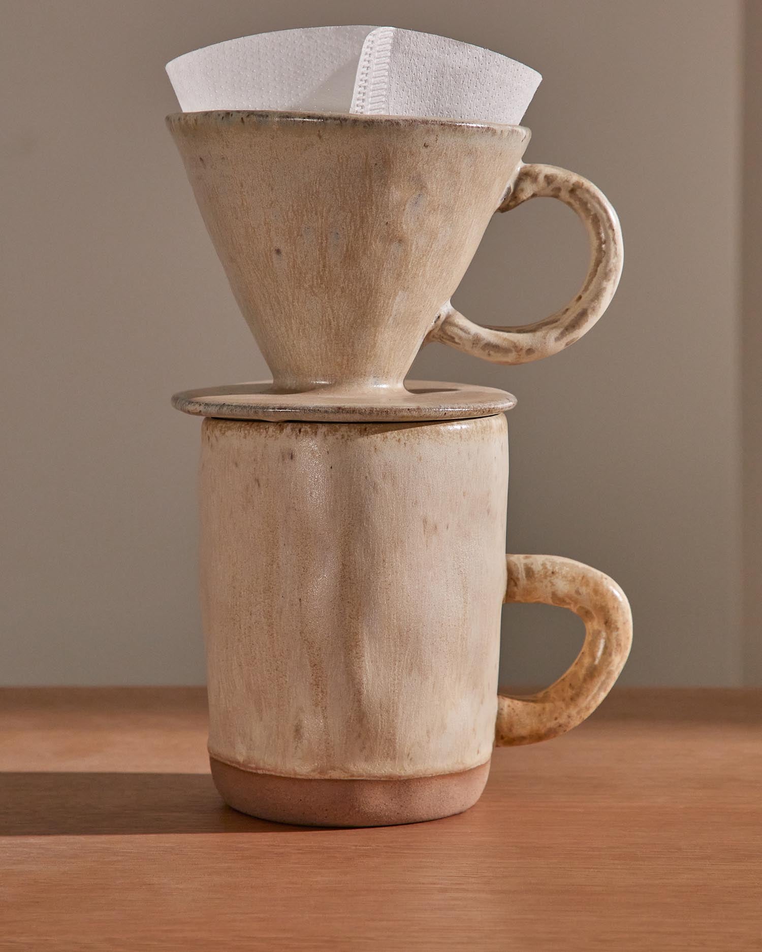 Entdecken Sie das elegante Set Zunel von Kave Home: eine stilvolle Tasse mit Kaffeefilter aus hochwertiger Keramik in zeitlosem Beige.