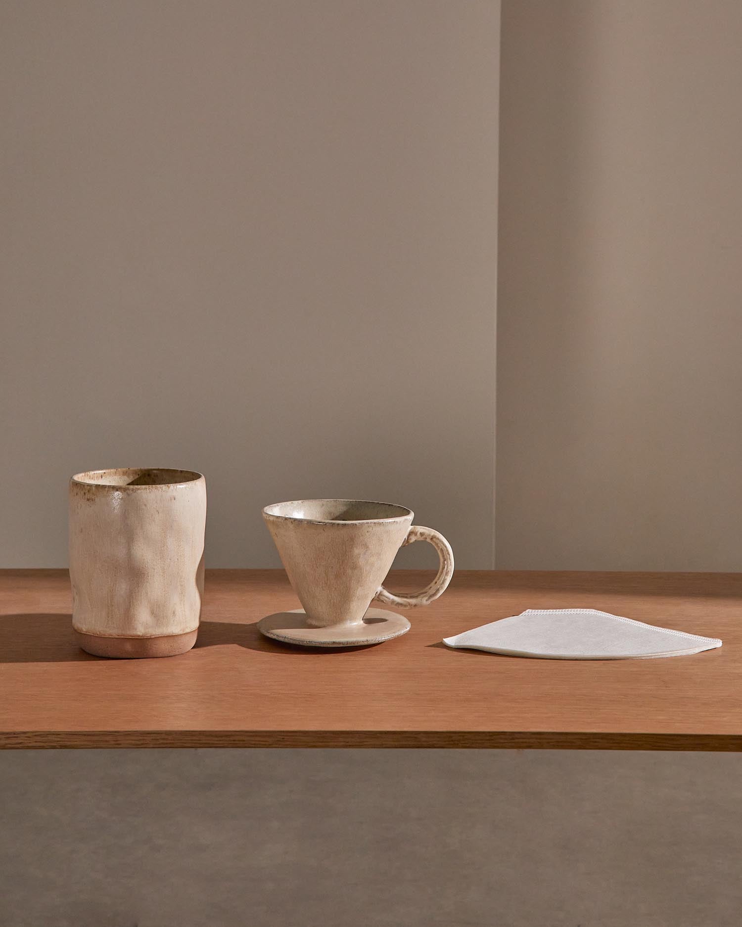 Genießen Sie Kaffee stilvoll mit dem Set Zunel von Kave Home: Tasse und Kaffeefilter aus langlebiger Keramik in elegantem Beige.