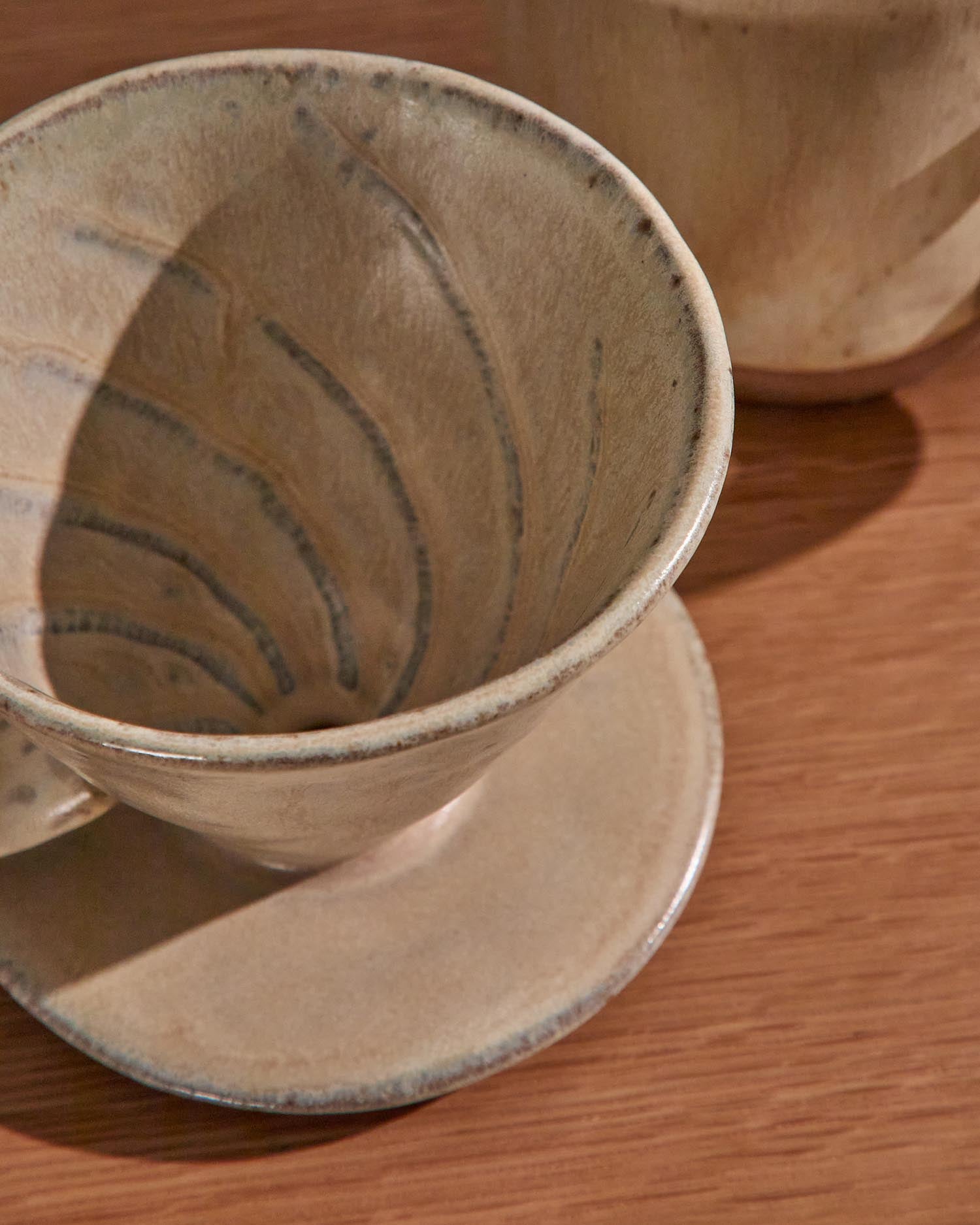 Genießen Sie Kaffee mit Stil: Das Set Zunel von Kave Home vereint elegante Keramiktasse und Kaffeefilter in edlem Beige.