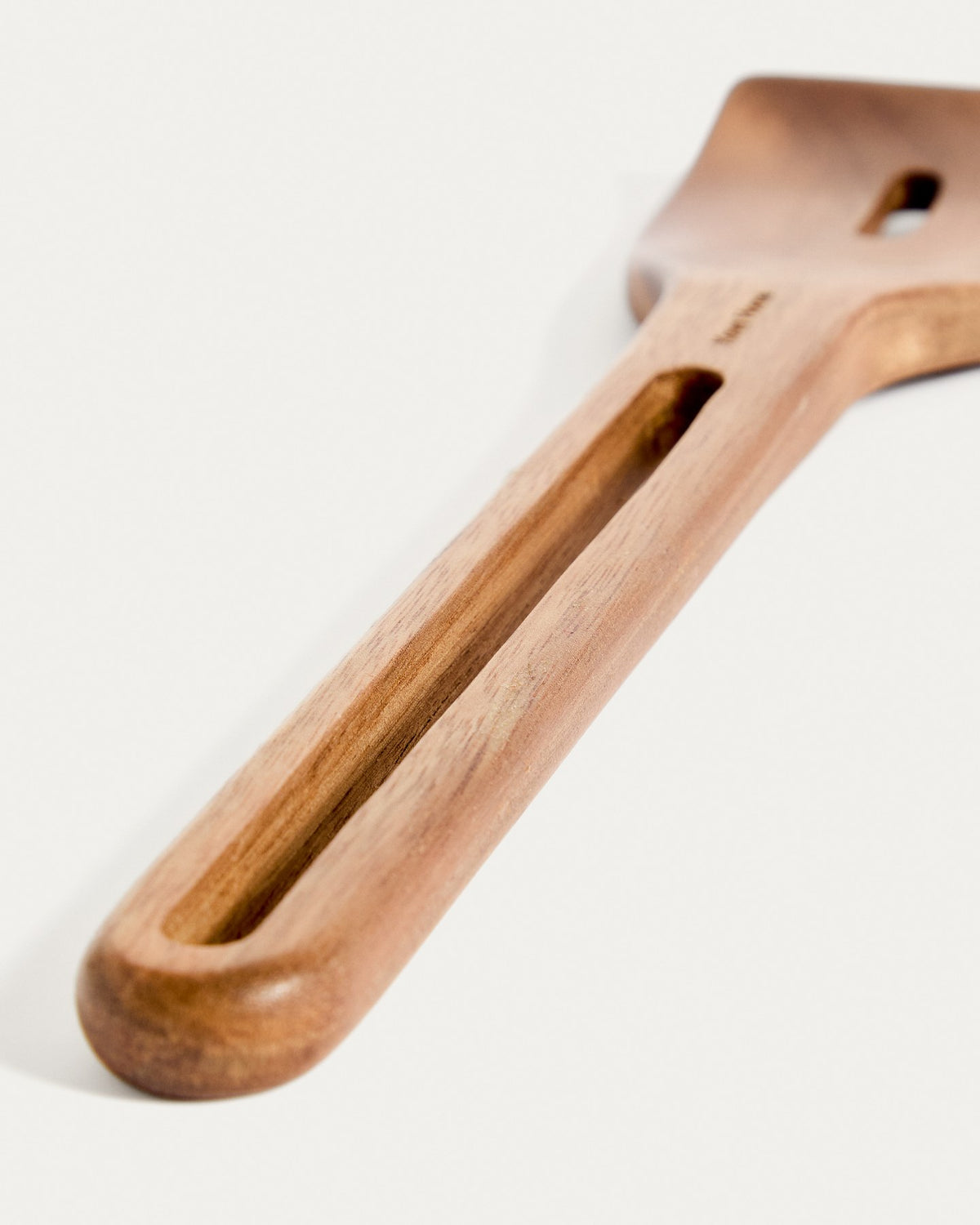 Küchenaccessoire Blera aus lackiertem Akazienholz in Naturton, längliche Form mit Loch zum Aufhängen, sichtbare natürliche Holzmaserung.