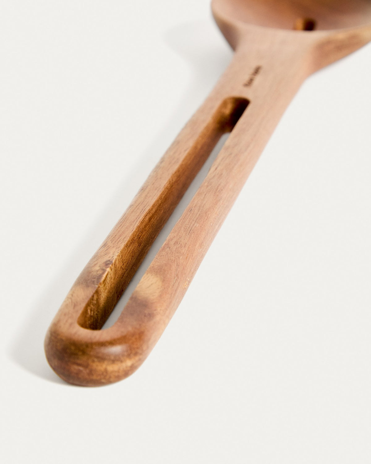 Küchenaccessoire Blera aus lackiertem Akazienholz in Naturton, längliche Form mit Loch zum Aufhängen, sichtbare natürliche Holzmaserung.