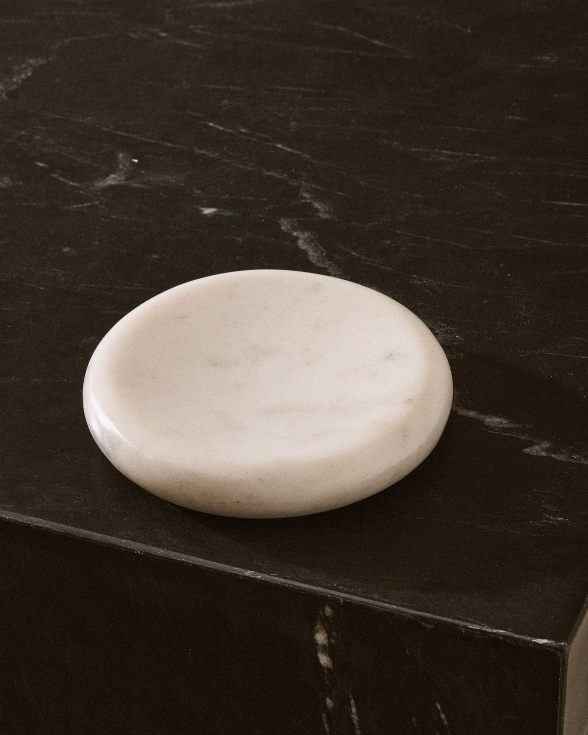 Rundes weisses Marmortablett Obena mit 15 cm Durchmesser und 2.5 cm Höhe, Oberfläche zeigt natürliche Maserung und individuelle Farbnuancen.