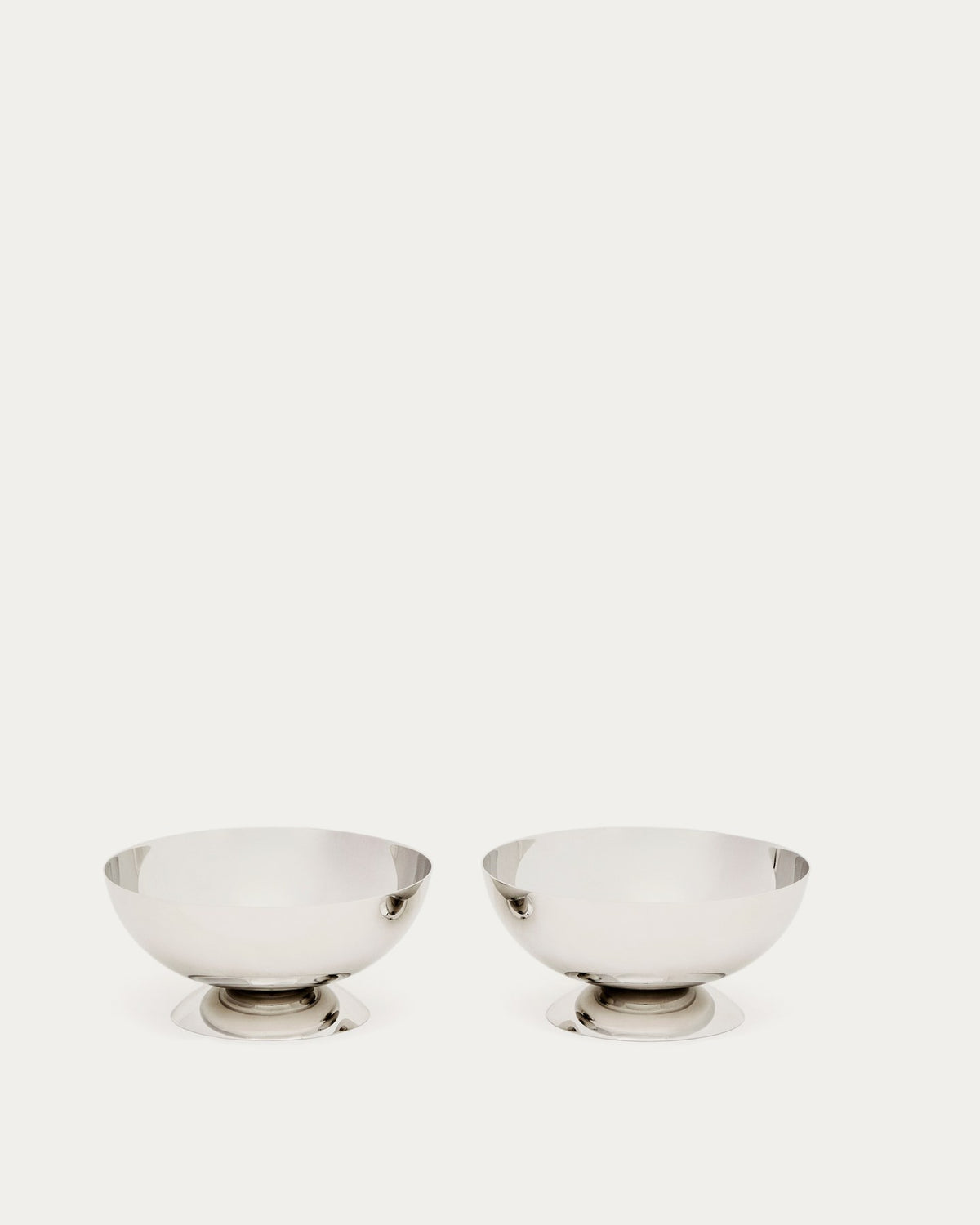 Zwei runde Schalen aus glänzendem, rostfreiem Edelstahl in Silber, stapelbar, mit glatter Oberfläche und schlichter Form.