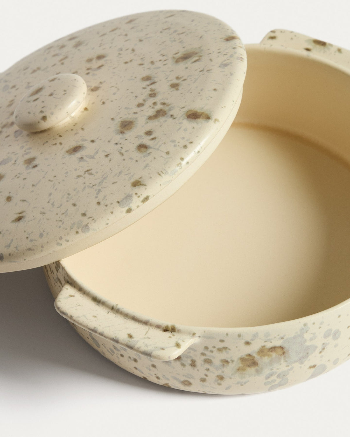 Weisse Auflaufform aus Keramik mit braunem Aufdruck und Deckel, gesprenkeltes Finish durch reaktive Glasur, rechteckige Form für den gedeckten Tisch.