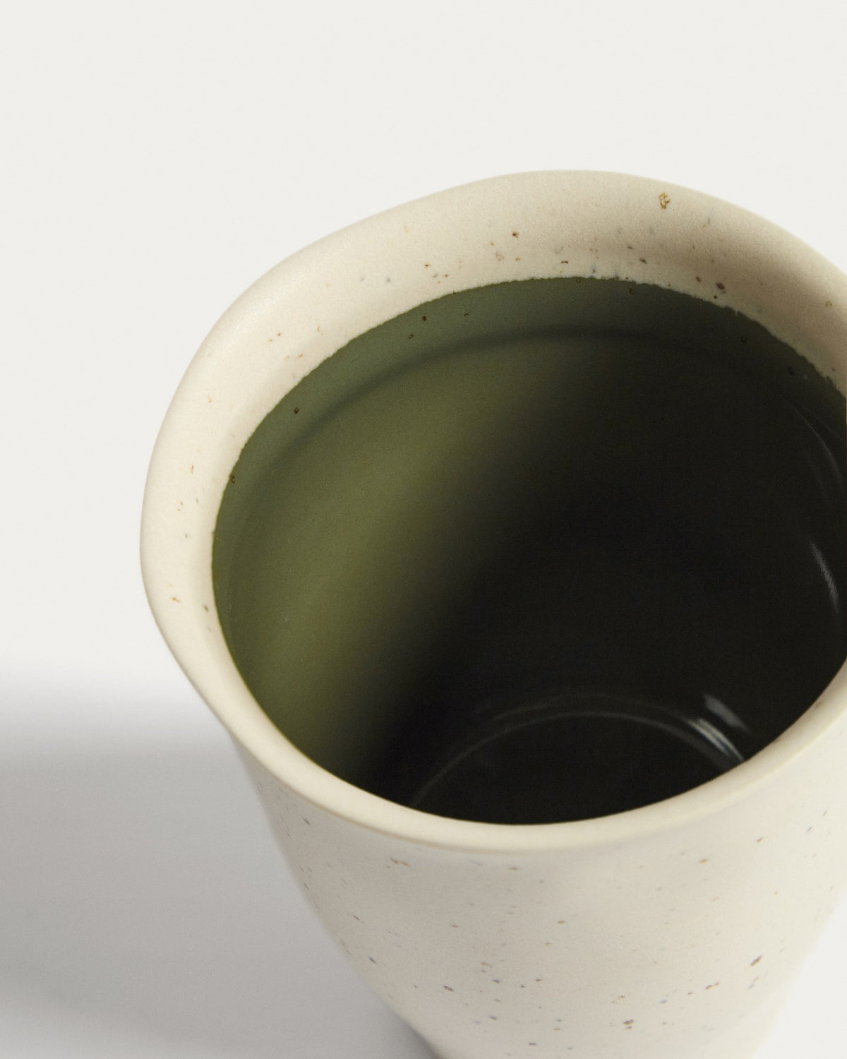 Keramiktasse Nale von Kave Home in Beige mit glänzendem grünem Boden, schlichte Form, Durchmesser 9 cm, Höhe 11 cm.
