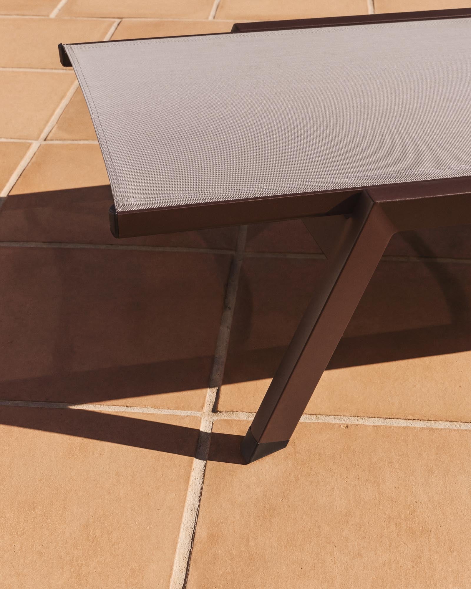 Stapelbare Sonnenliege Capraia in modernem Design, gefertigt aus braunem Aluminium und hellem Texteline, perfekt für Garten und Terrasse.