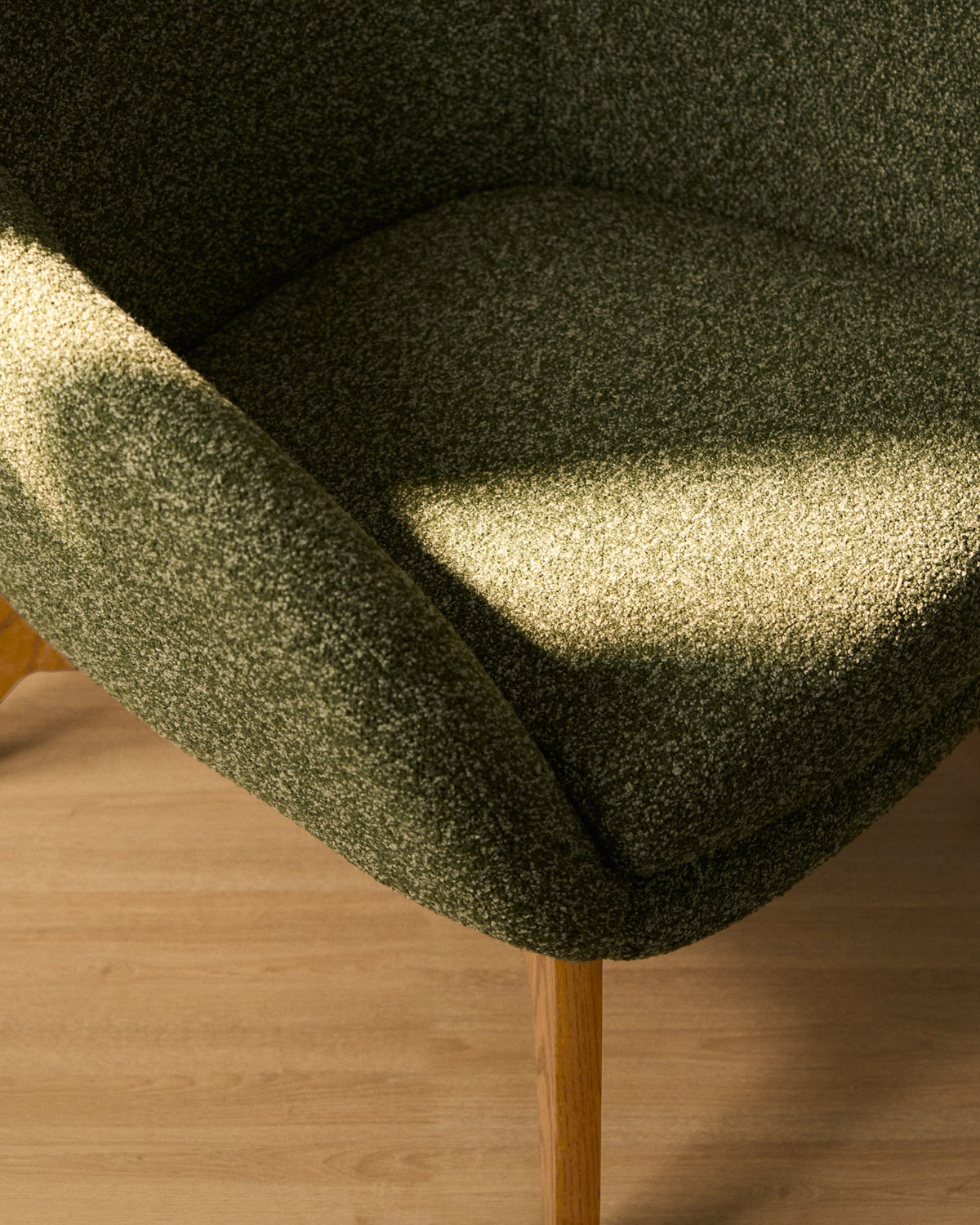 Sessel Adiran von Kave Home mit dunkelgrünem Chenille-Bezug, Armlehnen und Beinen aus massivem Eichenholz mit natürlichem Finish.