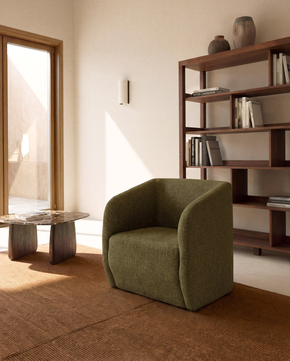 Sessel Milare von Kave Home mit olivgrünem Chenille-Bezug, abgerundeter Rückenlehne und Armlehnen sowie Kunststoffgleitern an den Beinen.