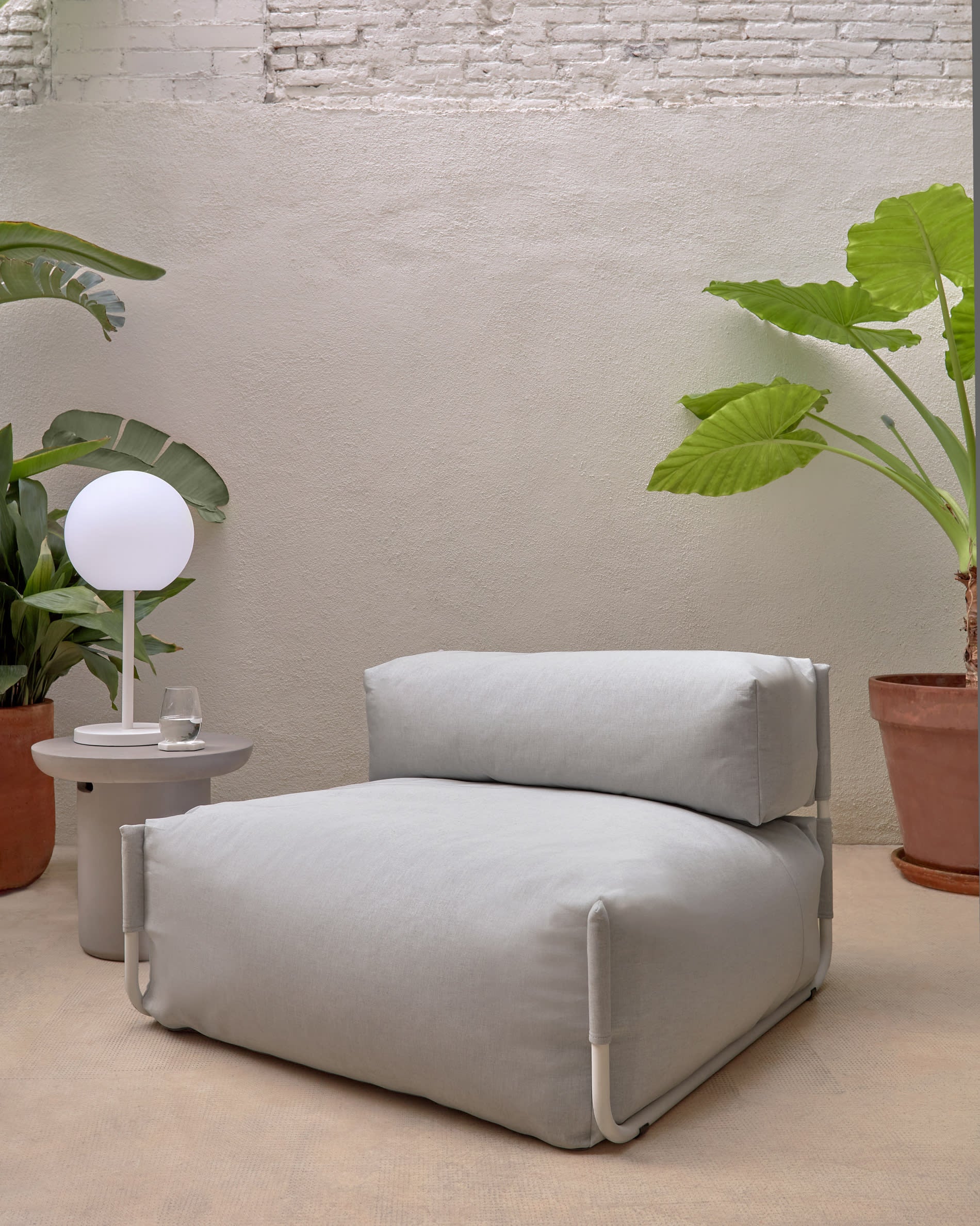 Elegantes Square Pouf Modularsofa in hellgrau mit Rückenlehne. Robuste, wetterfeste Materialien und individuelles Design für stilvolle Entspannung im Freien.