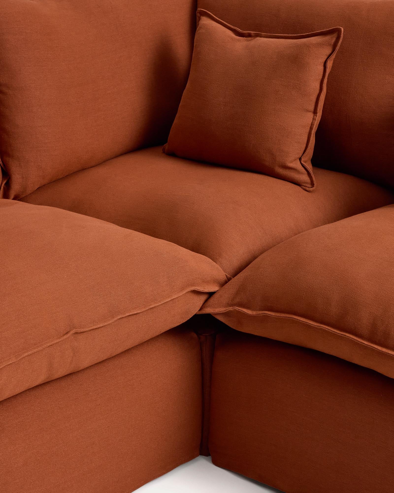 Modulares 4-Sitzer-Ecksofa Anarela in Terrakotta, mit abnehmbarem Leinenbezug, vielseitig und nachhaltig, perfekt für moderne Wohnkonzepte.