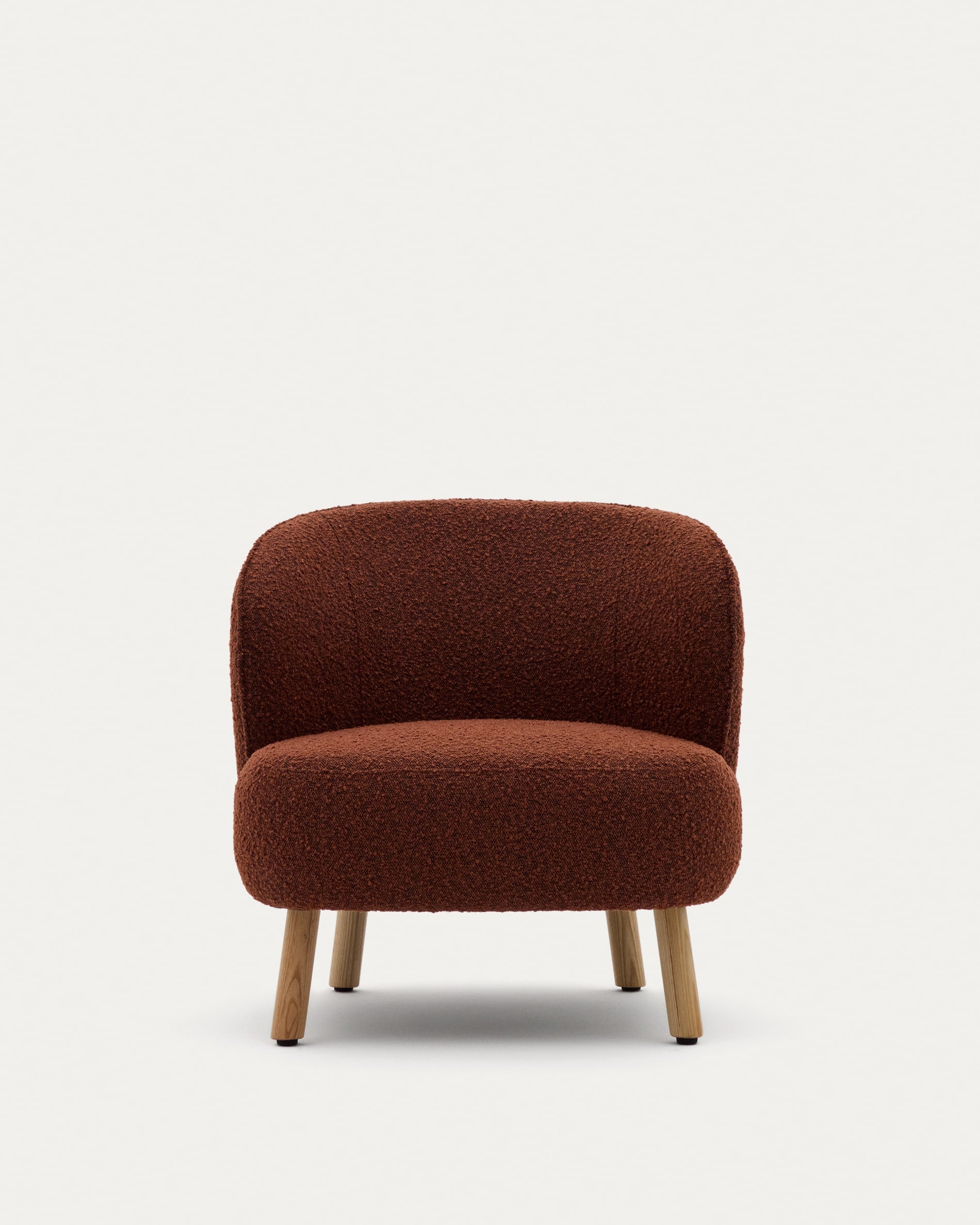 Sessel Ulit: Terrakottafarbenes Schaffell, massive Buchenholzbeine, natürliches Finish, stilvoll und perfekt für zeitgemässes Interieur.