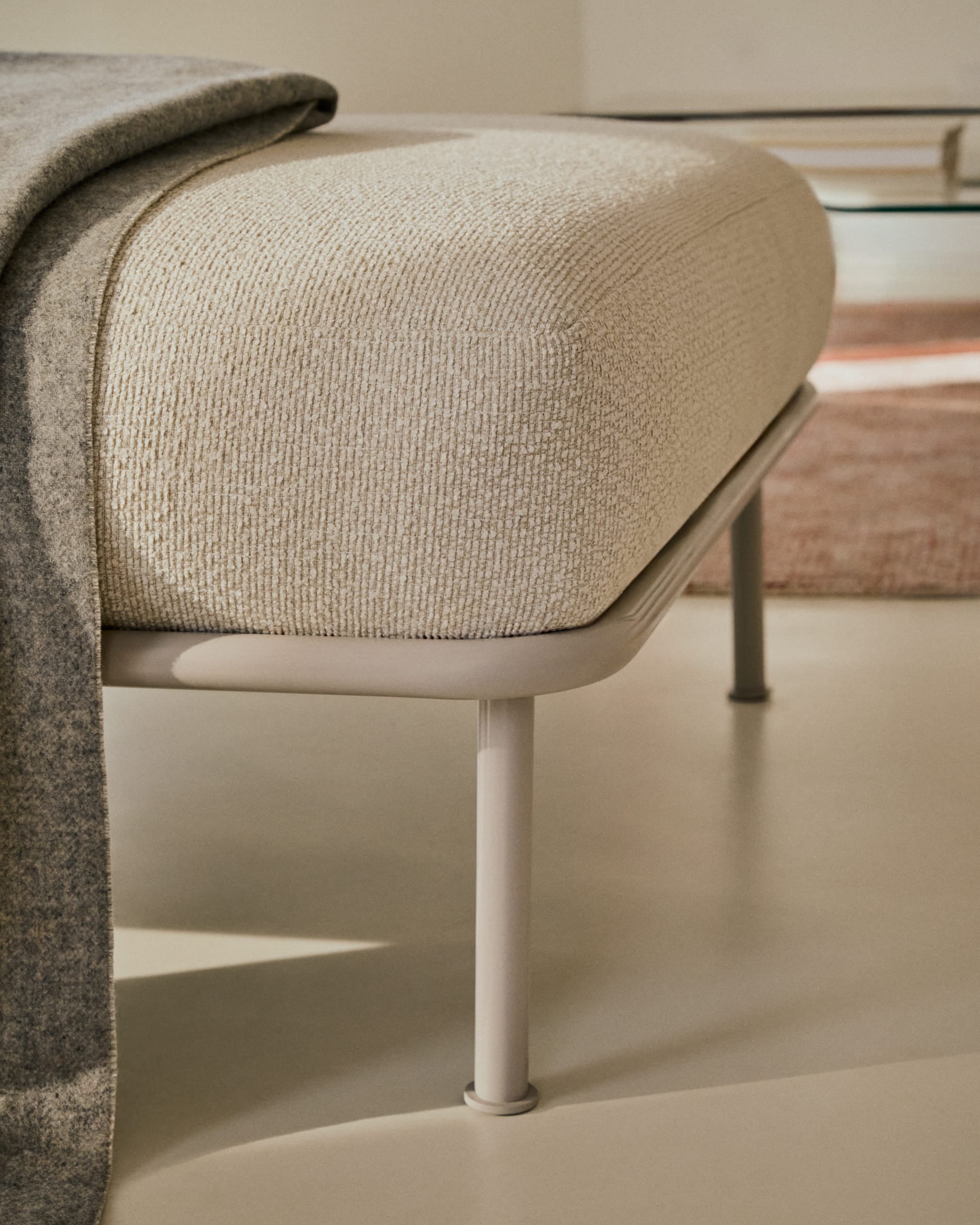 Stilvolle Fussablage Aurum in Ecru, 85 x 85 cm, mit pflegeleichtem Chenille-Bezug und stabiler Metallbasis. Ideal für moderne Wohnkonzepte.