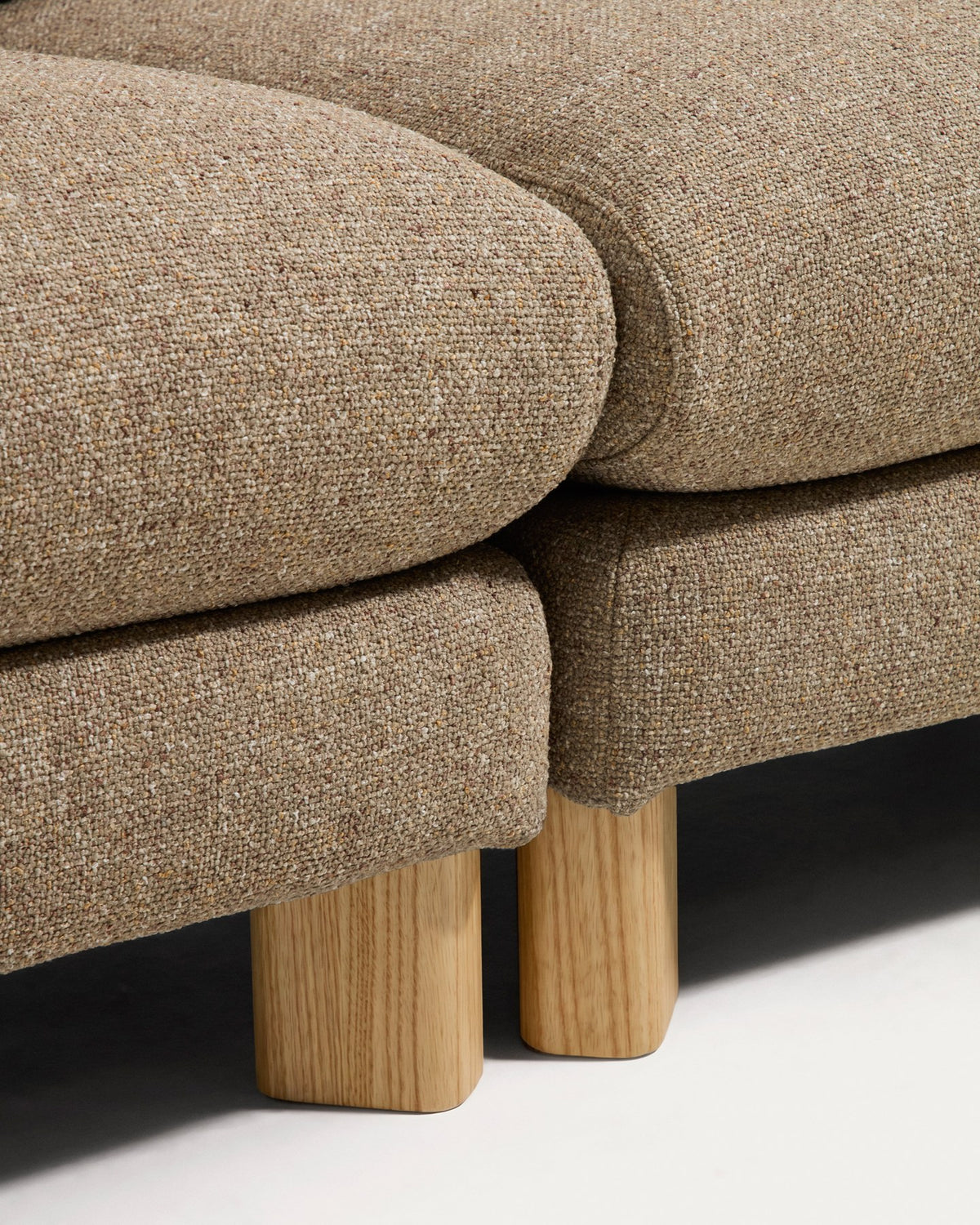 Hellbraunes 3-Sitzer Sofa Vera mit gepolsterter Sitzfläche, geschwungenen Armlehnen und sichtbaren Beinen aus massivem Eschenholz.