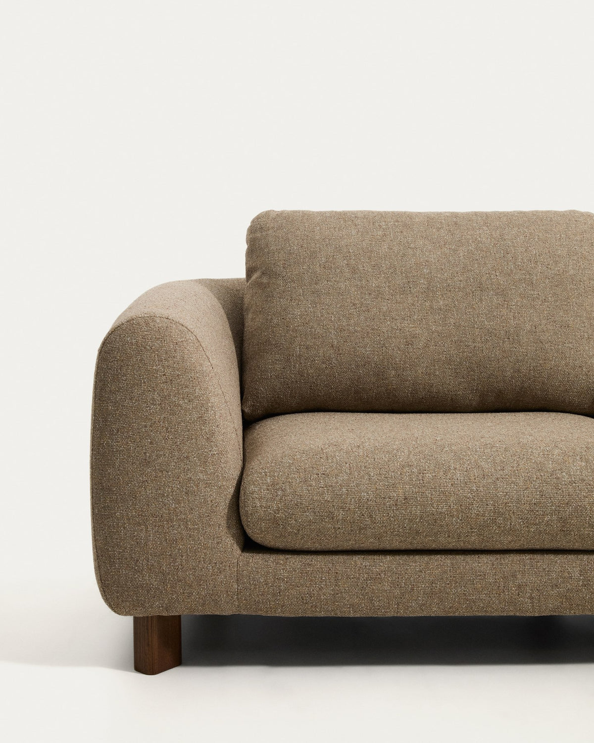 4-Sitzer Sofa Vera in Hellbraun mit gepolsterten Armlehnen und sichtbaren Beinen aus massivem Eschenholz mit Nussbaum-Finish.