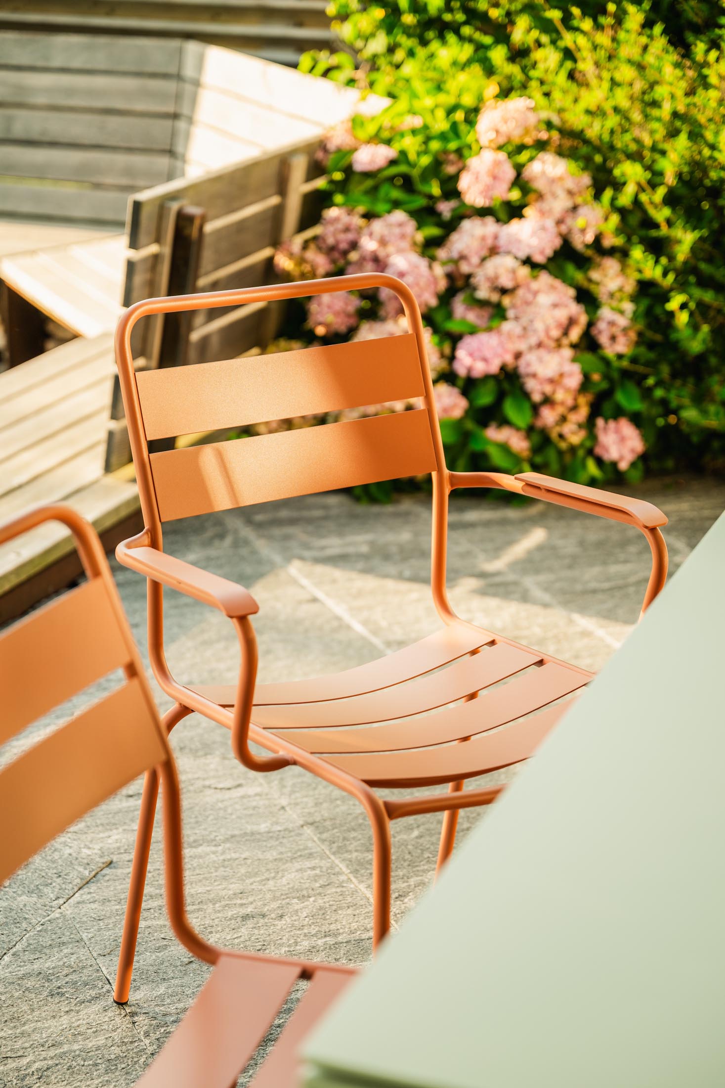 Glarus Ganzmetall-Gartenstuhl mit Armlehne in Pastellterracotta präsentiert im Onlineshop von KAQTU Design AG. Gartenstuhl mit Armlehnen ist von Schaffner