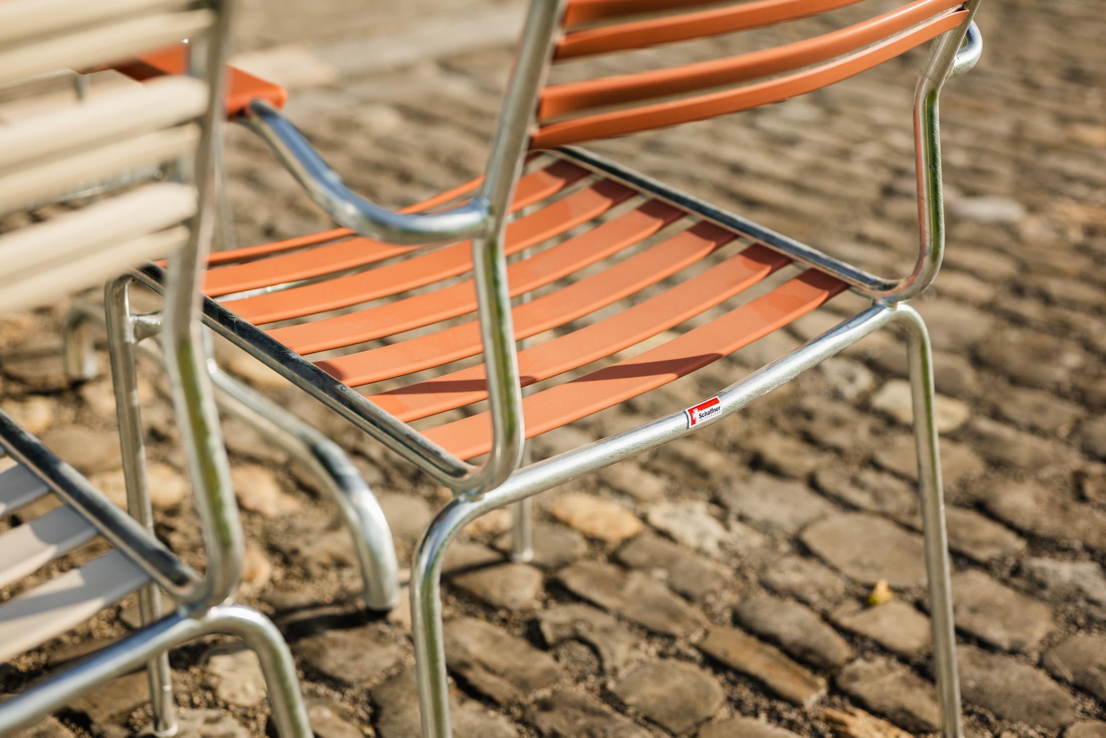 Säntis Lättli-Gartenstuhl mit Armlehne in Pastellterracotta präsentiert im Onlineshop von KAQTU Design AG. Gartenstuhl mit Armlehnen ist von Schaffner