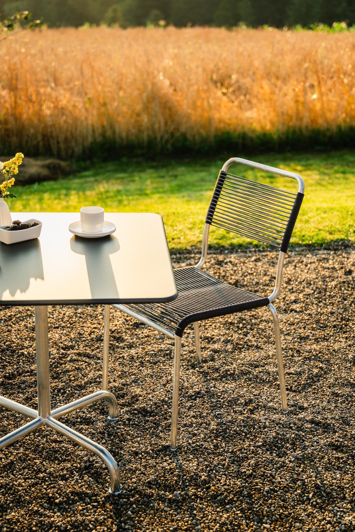 Entdecken Sie den langlebigen, wetterfesten Rigi Spaghetti-Gartenstuhl ohne Armlehne aus Schweizer Eschenholz – elegantes Design für Ihren Outdoor-Bereich.