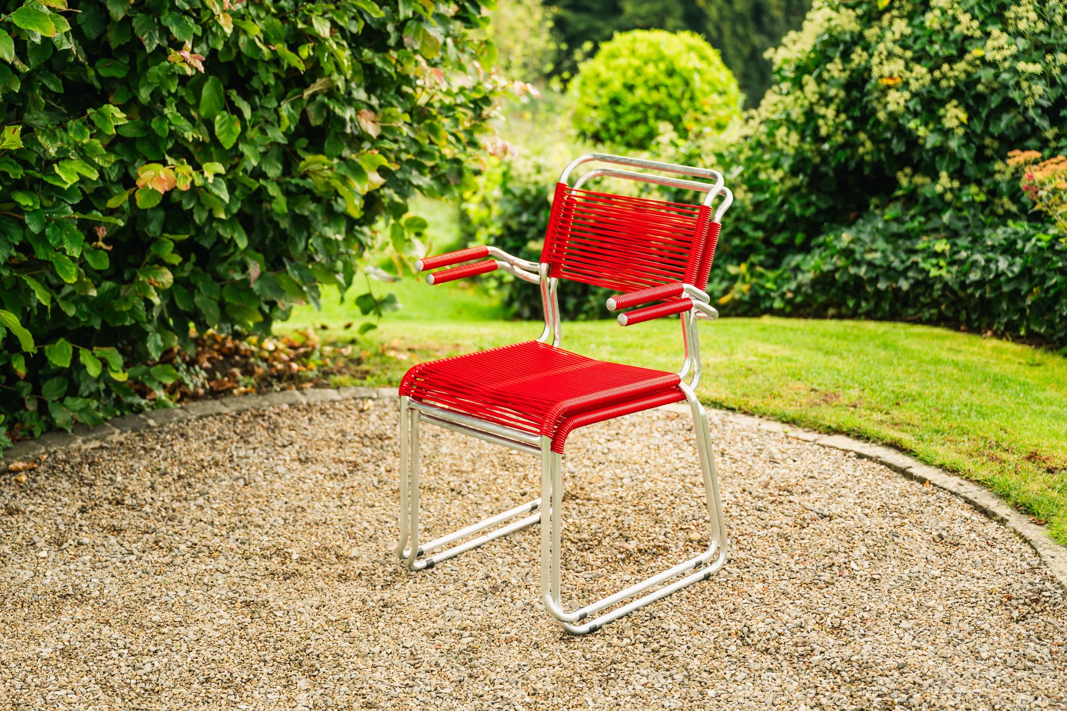Eleganter Säntis Spaghetti-Gartenstuhl mit Armlehne, wetterfestes Metall, nachhaltige OceanYarn®-Bespannung, langlebig, Schweizer Qualität, ideal für Terrasse.