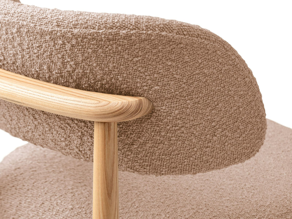 Zwei Boucle-Stühle Evan in Beige mit Buchenholz-Beinen, strukturiertem Bouclé-Bezug und gepolsterter Sitzfläche vor neutralem Hintergrund.