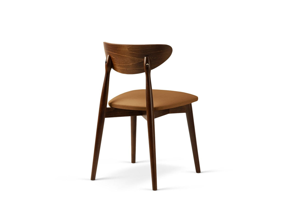 Zwei Leon Stühle mit Samtbezug in Almond Beige, Buchenholz-Beinen und gepolsterter Rückenlehne, Frontalansicht auf hellem Hintergrund.