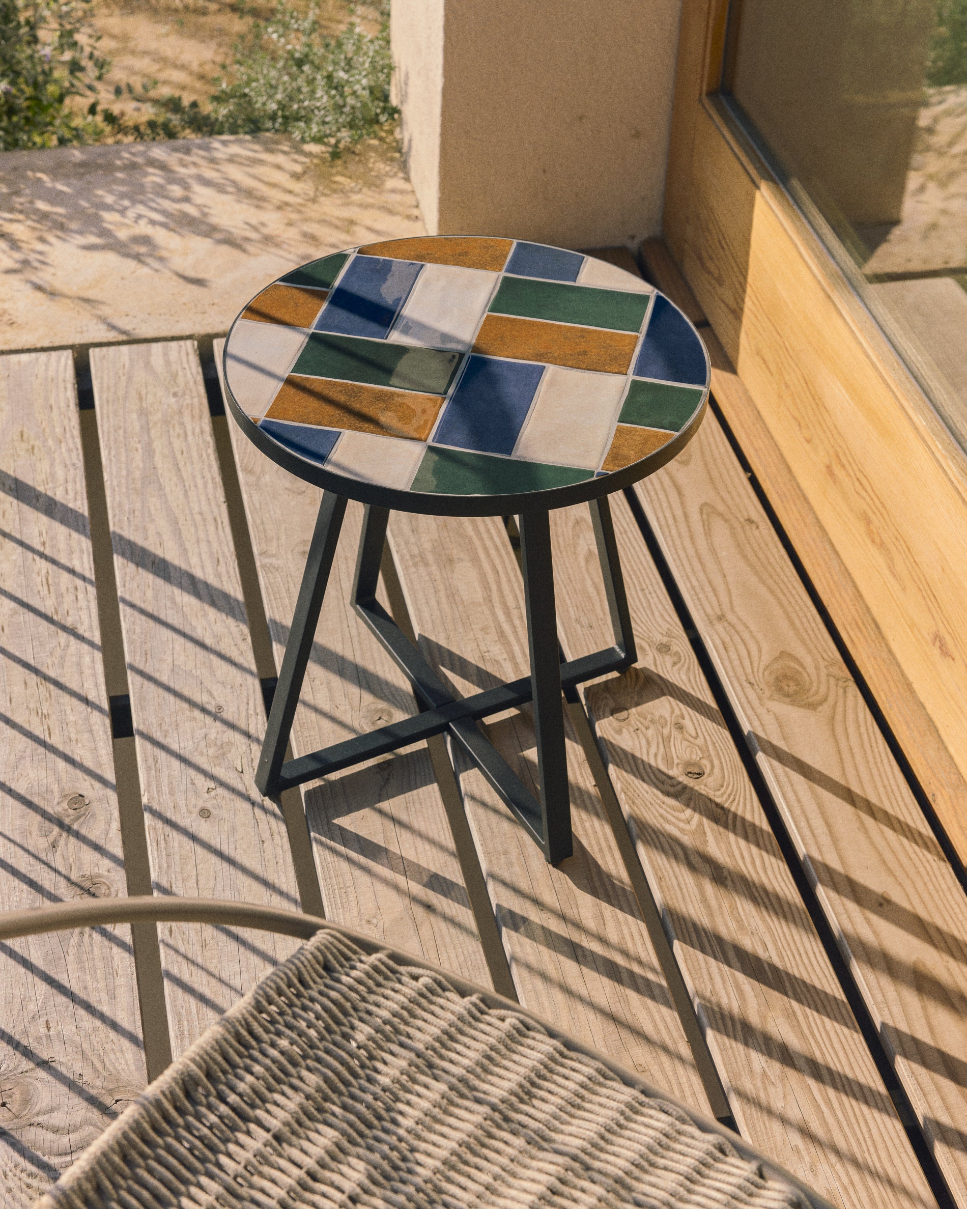 Eleganter runder Beistelltisch Tella aus verzinktem grafitfarbenem Stahl, geschmückt mit farbenfrohen Fliesen, perfekt für den Garten oder die Terrasse.