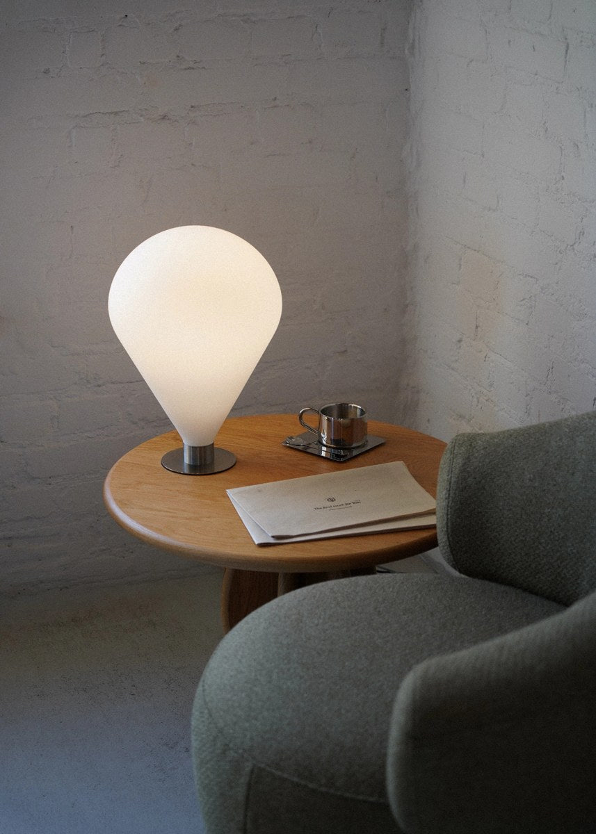 Tischlampe Ely mit rundem Lampenschirm aus mattem Glas und Sockel aus Stahl, Touch-Bedienfeld am Fuss der Leuchte sichtbar.