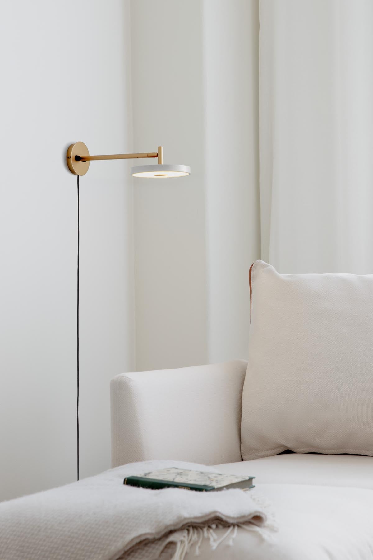 Moderne Asteria Wandleuchte long mit Kabel in zartem Mist, perfekt für eine stilvolle Beleuchtung und Akzentuierung in Wohnräumen.