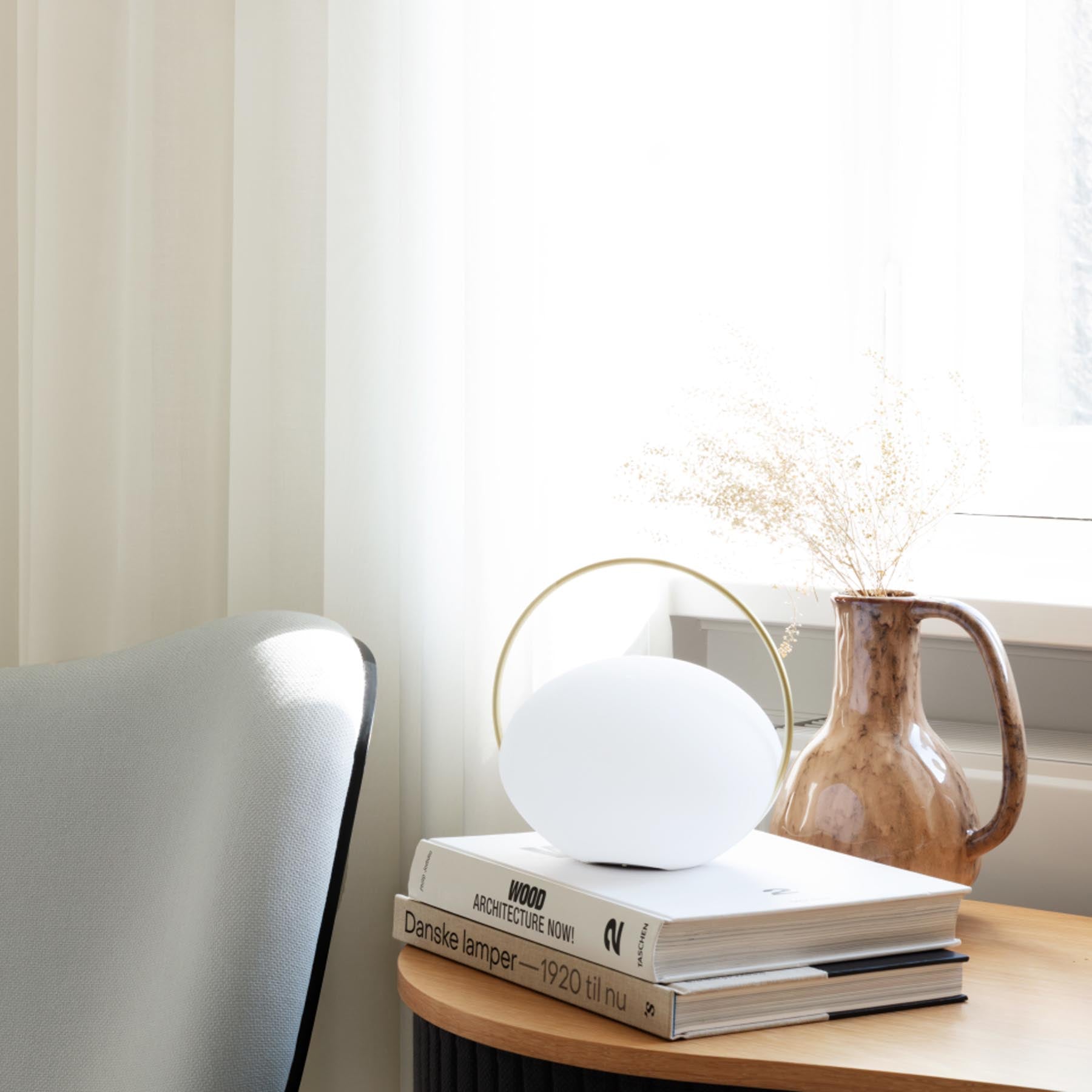 Stilvolle Orbit Tischleuchte von Umage, die durch ihr minimalistisches Design und sanfte Beleuchtung eine gemütliche Atmosphäre schafft.
