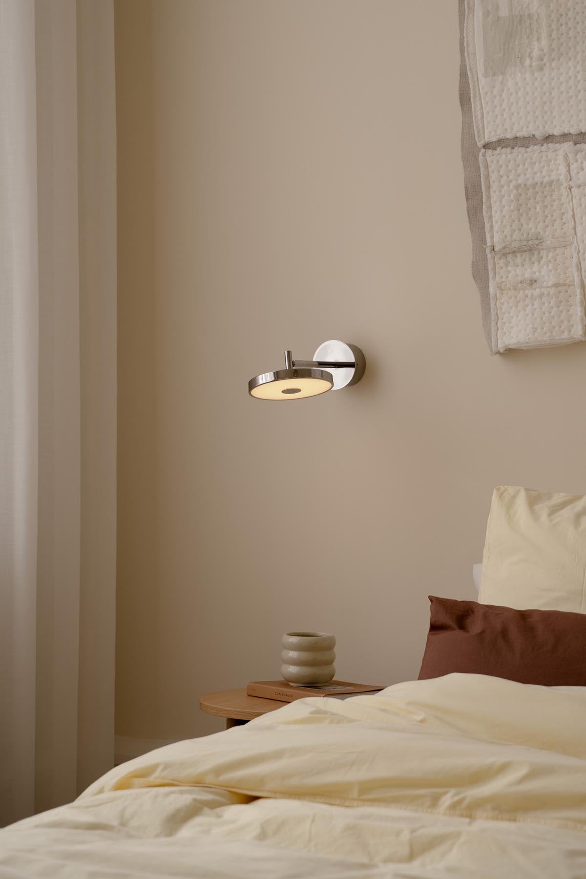 Elegante Asteria Wandleuchte short Hardwired von Umage in poliertem Stahl, ideal für stilvolle Innenräume.