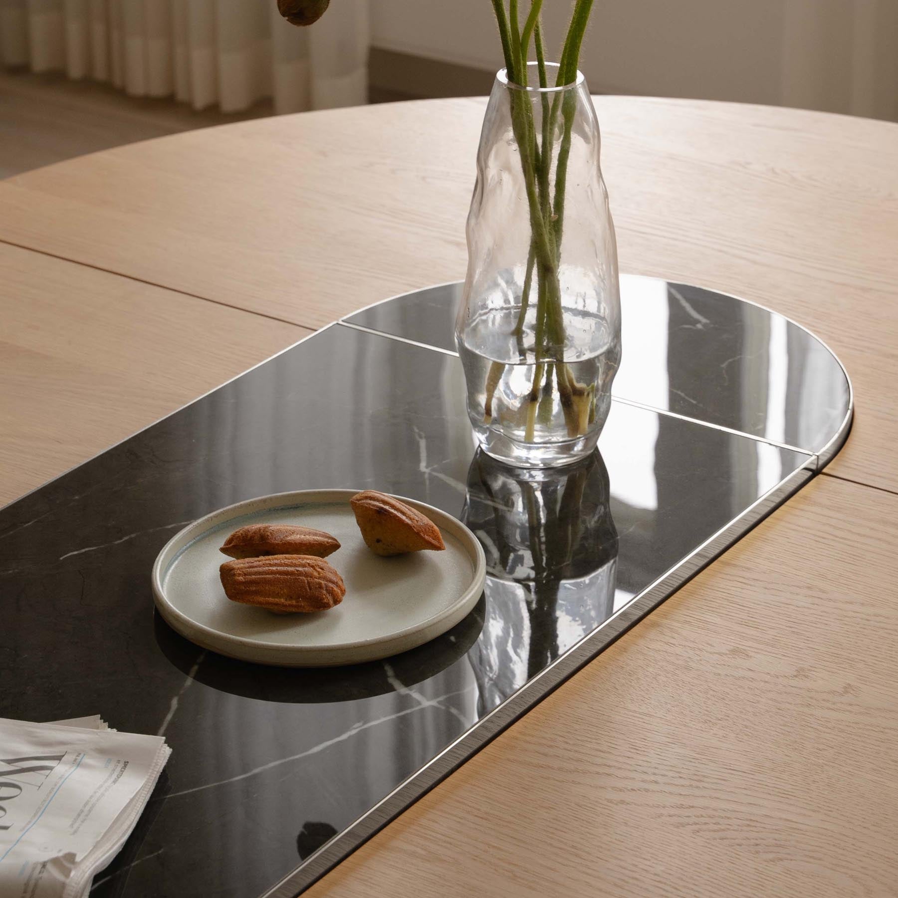 Eleganter Comfort Circle Esstisch von Umage, ausziehbar und in stilvollem Nero steel/Rippled Design, ideal für gesellige Runden.