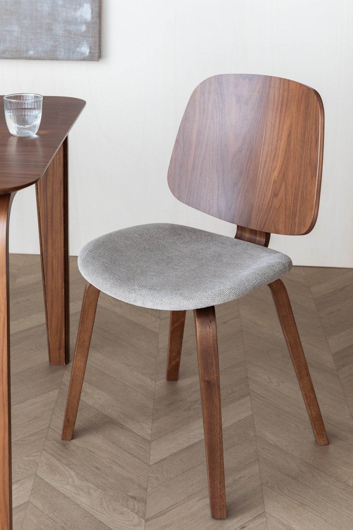 Foto eines beigen Stuhls mit gepolsterter Sitzfläche aus Polyester, Schaumstofffüllung und Beinen aus gebogenem Holz.