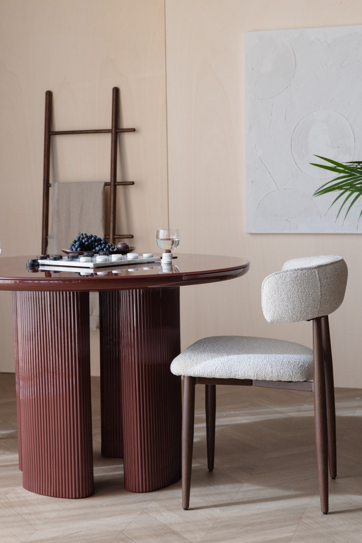 Runder Esstisch Dining Table Timo mit roter Hochglanz-Tischplatte und schwarzem Gestell aus Eisen mit vier gerillten Beinen in der Mitte.