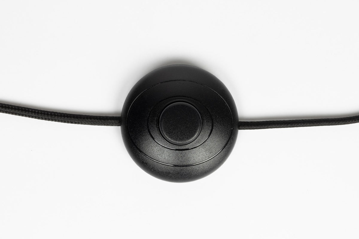 Stehleuchte Pim von White Label Living mit rundem Lampenschirm aus Stoff und Lampenkörper aus Eisen, Kabel in Schwarz.