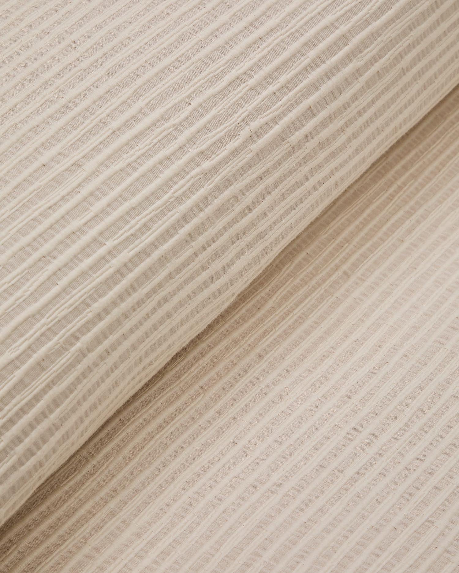 Elegante Tagesdecke Vindi in Ecru, aus 100% Baumwolle, mit fantasievollen Streifen. Ideal für Betten 90/135 cm, pflegeleicht und stilvoll.