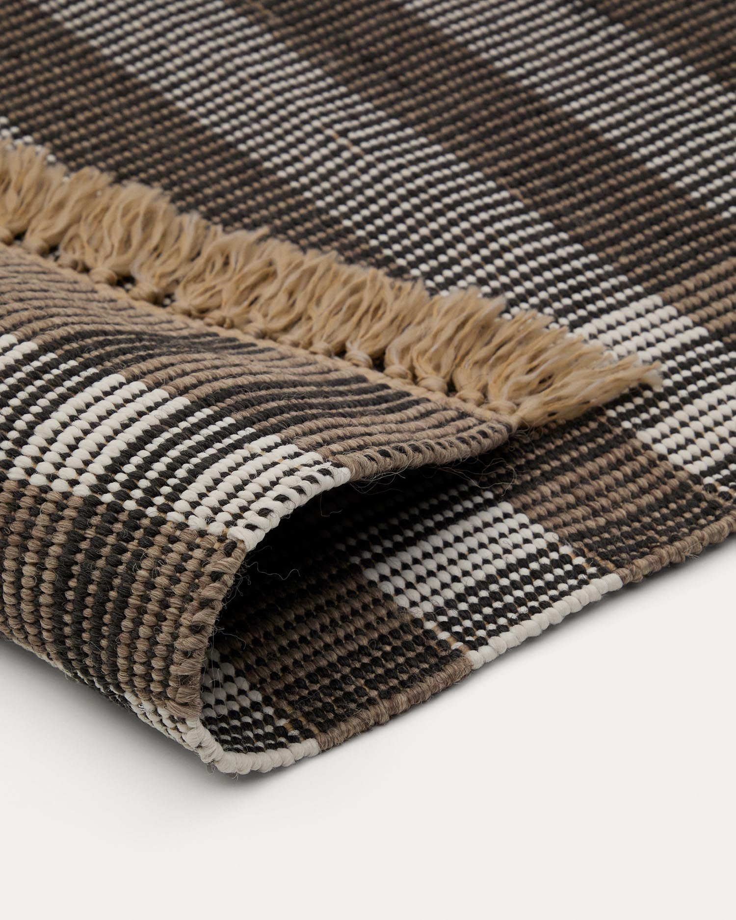 Erleben Sie den Teppich Barani (60 x 90 cm) von Kave Home – ein elegantes, handgefertigtes Accessoire aus robusten Synthetikfasern in stilvollem Braun und Schwarz.