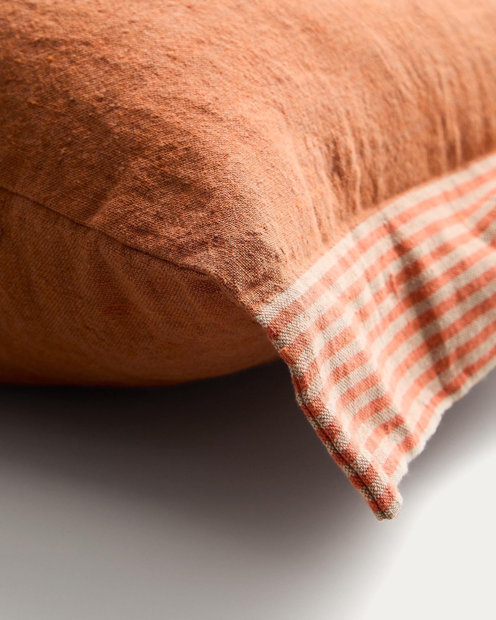 Stilvoller Kissenbezug Disea aus feinem Leinen in lebhaftem Orange, verziert mit einem ansprechenden Streifenmuster, perfekt für jedes Zuhause.