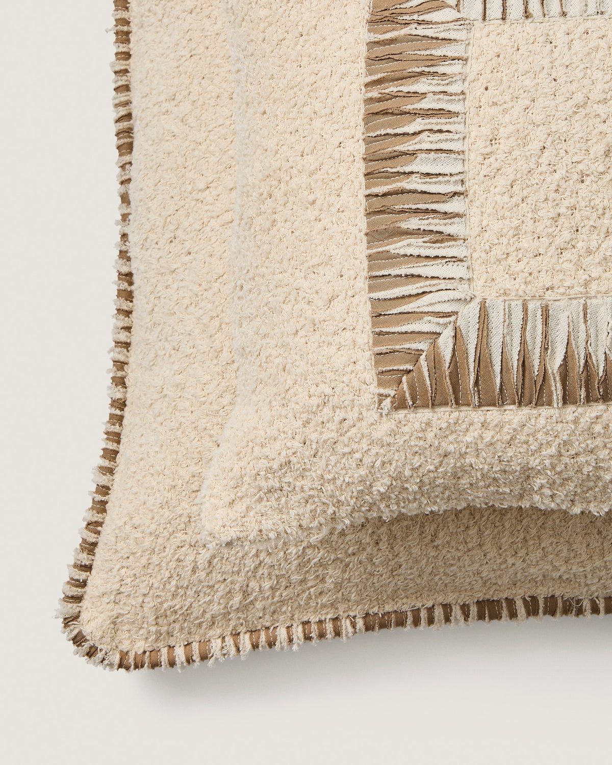 Beige quadratischer Kissenbezug aus Baumwoll-Bouclé-Gewebe mit brauner Kontrastpaspel am Rand, Grösse 50 x 50 cm, Nahaufnahme der Textur.