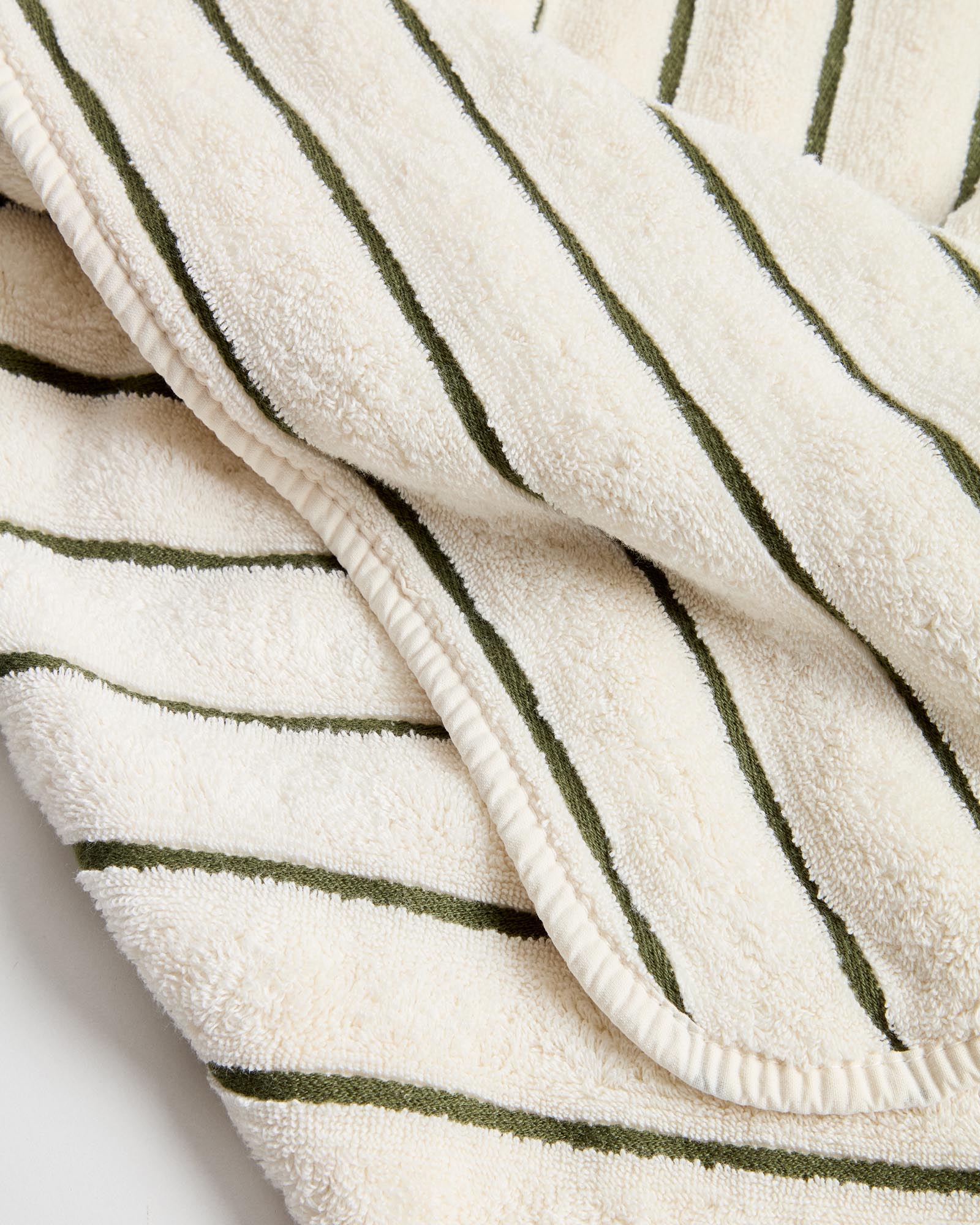 Elegantes Handtuch Dorane in sanften Grüntönen, gefertigt aus 100 % Baumwolle, ideal für ein modernes Badezimmer und täglichen Komfort.