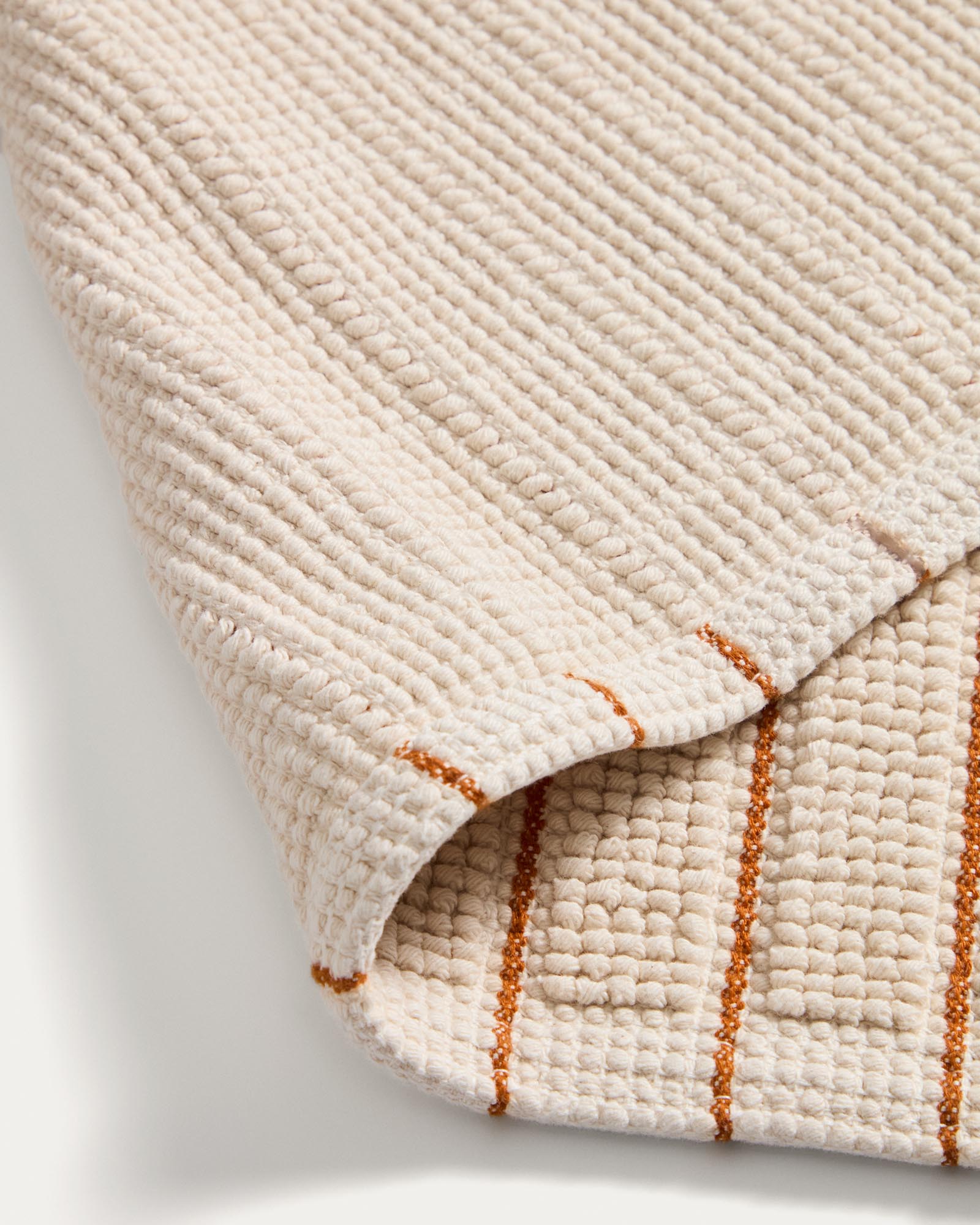 Badezimmermatte Merade aus weicher Baumwolle, 50 x 80 cm, mit lebhaften orangefarbenen Streifen, perfekt für ein stilvolles Badezimmer von Kave Home.
