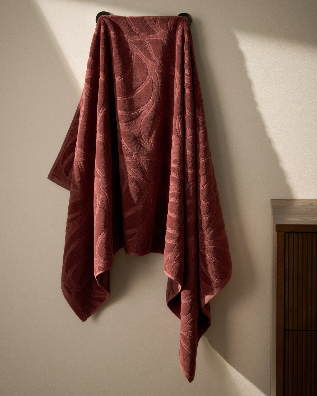 Weinrotes Badetuch aus Baumwolle mit Jacquard-Muster und samtiger Oberfläche, Grösse 70 x 140 cm, gefaltet dargestellt.